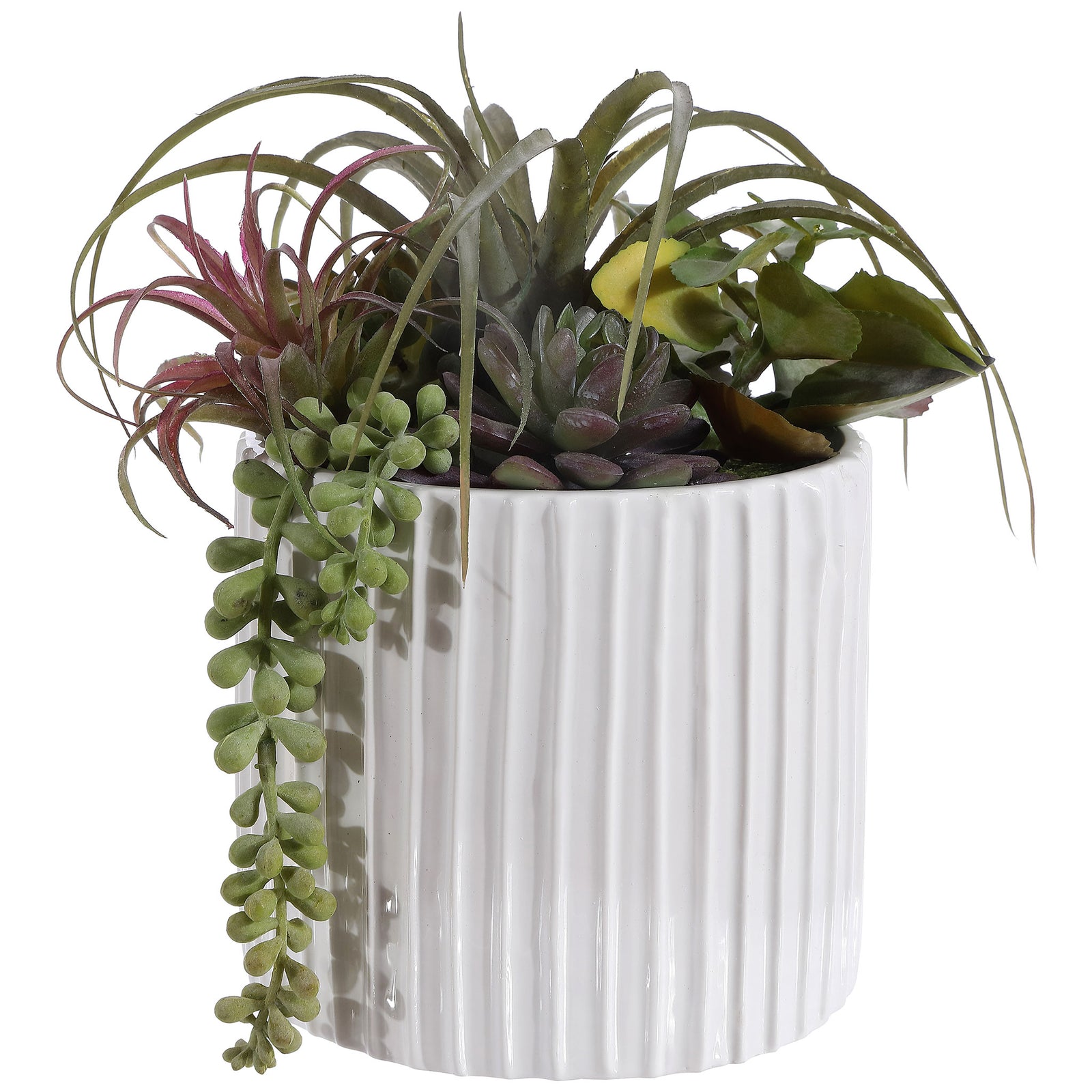 Green and purple faux succulents spill over a fluted white pot. || FXP1011A || front_studio