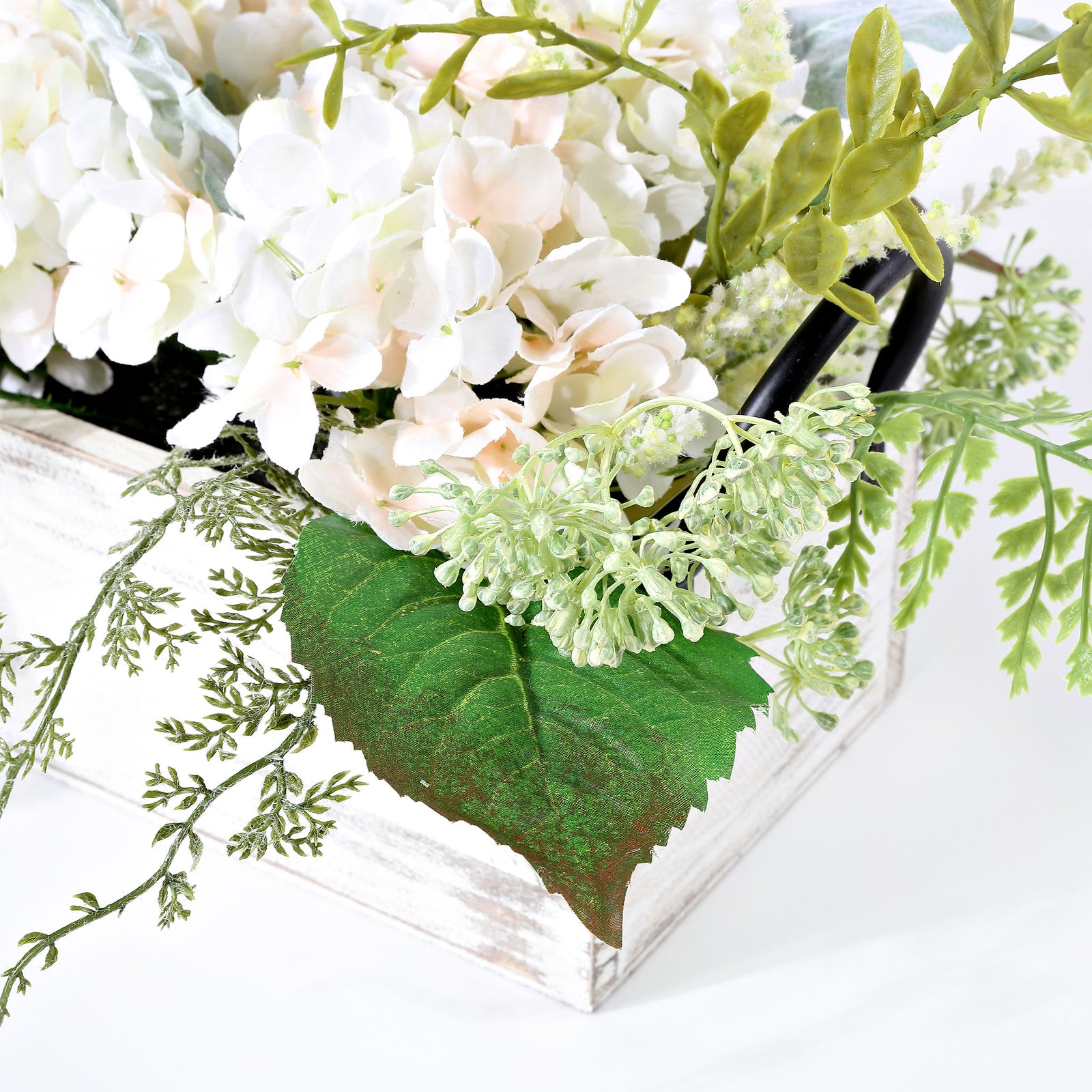 White hydrangeas and green foliage spill over a distressed planter. || FXP1014A || detail_studio