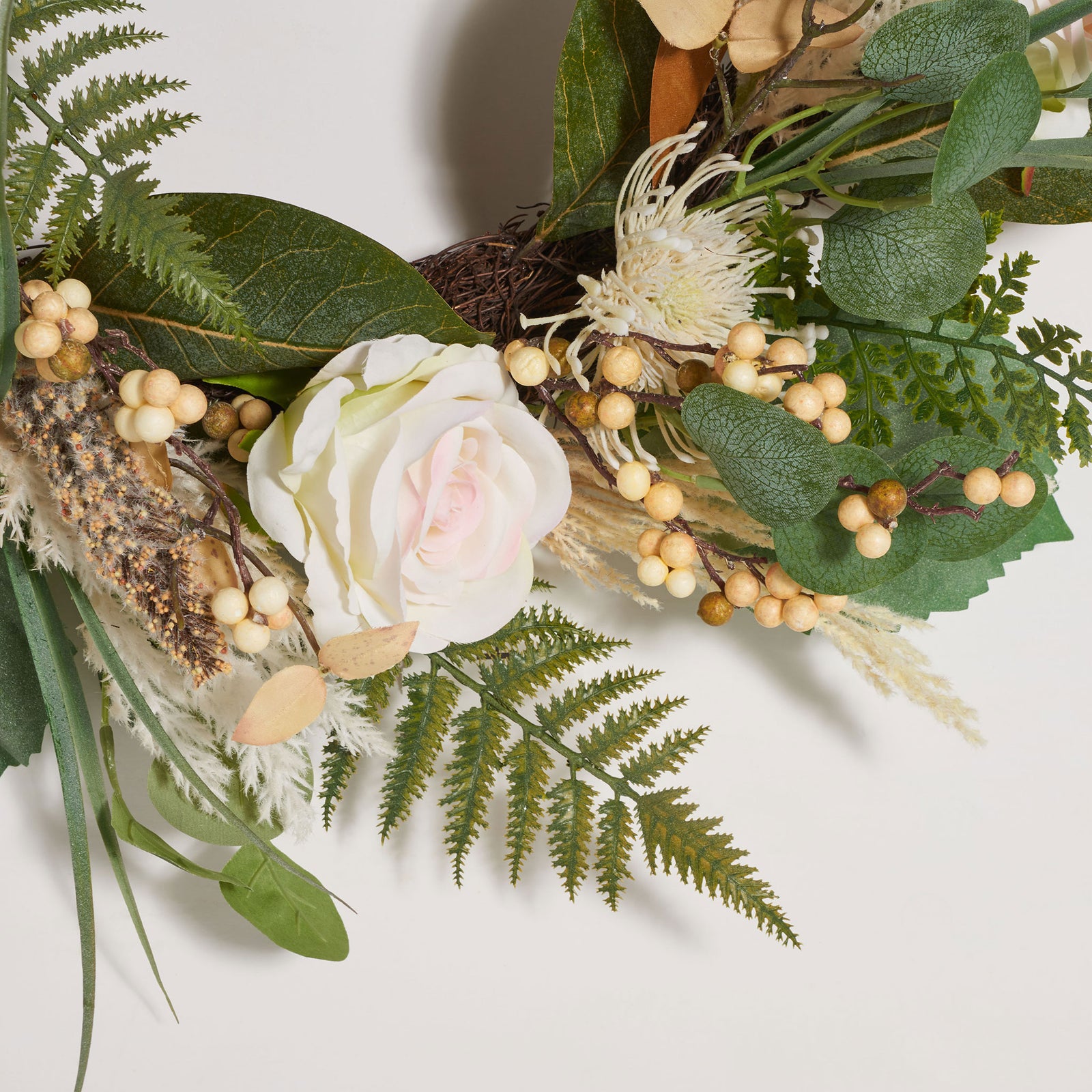 A pale rose nestles among delicate ferns, berries, and green leaves. || FXP1023A || detail_studio
