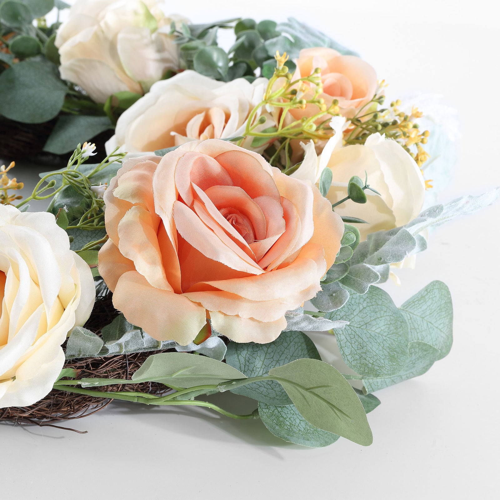 A peach rose blooms among silvery eucalyptus and pale floral accents. || FXP1024A || detail_studio