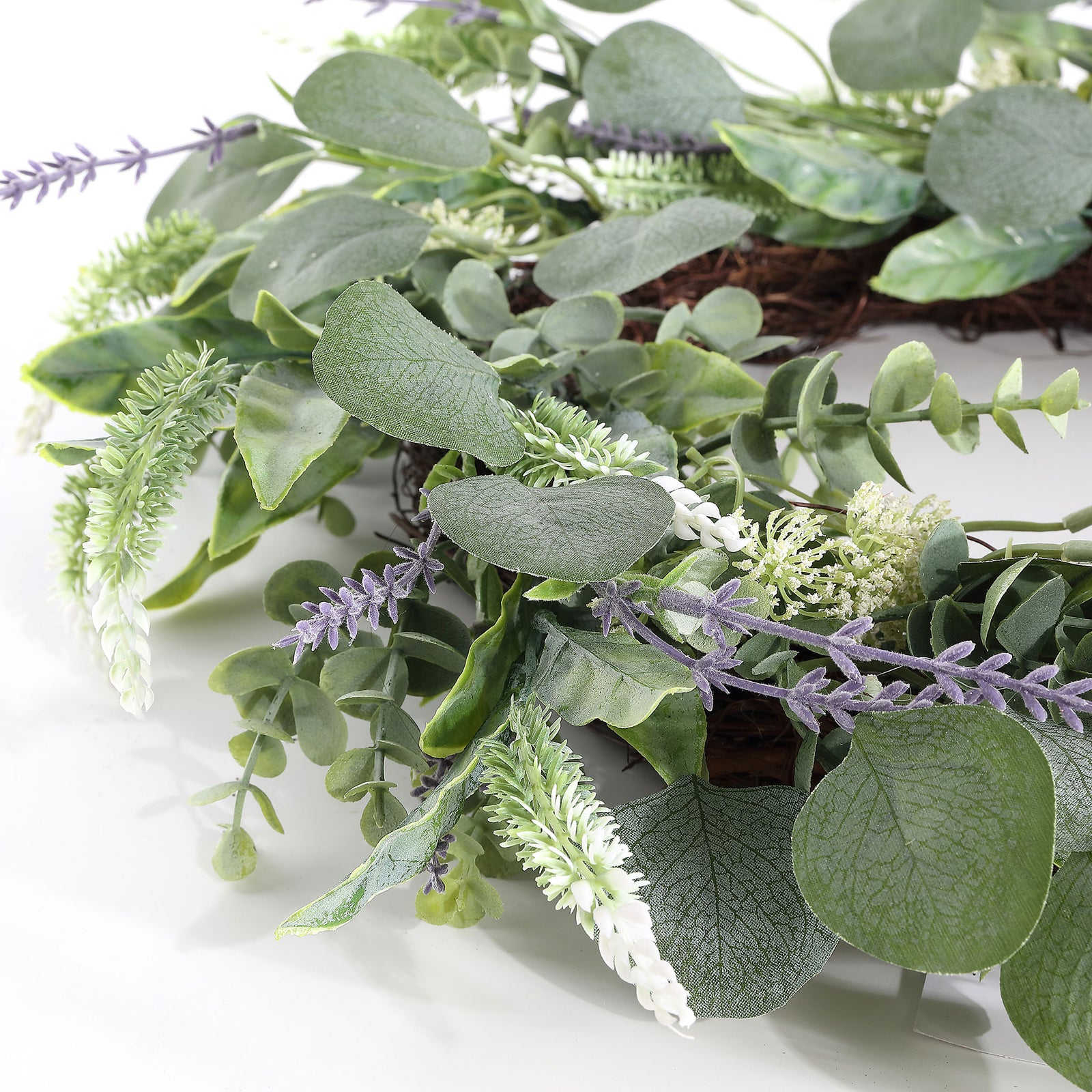 Pale flowering sprigs weave between textured leaves and purple accents. || FXP1029A || detail_studio