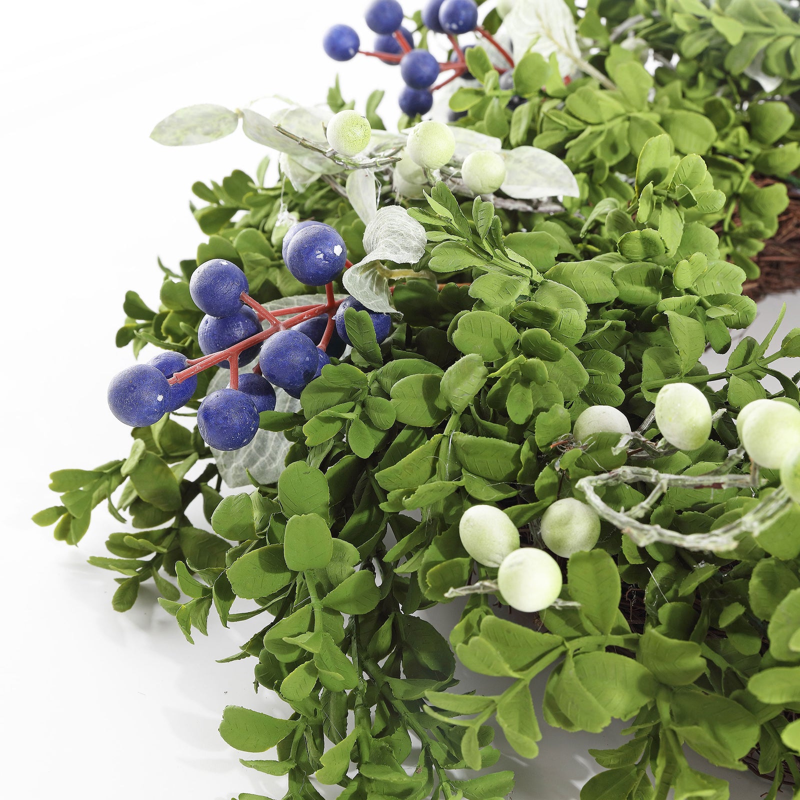 Blue berries and white accents pop against dense faux boxwood leaves. || FXP1038A || detail_studio