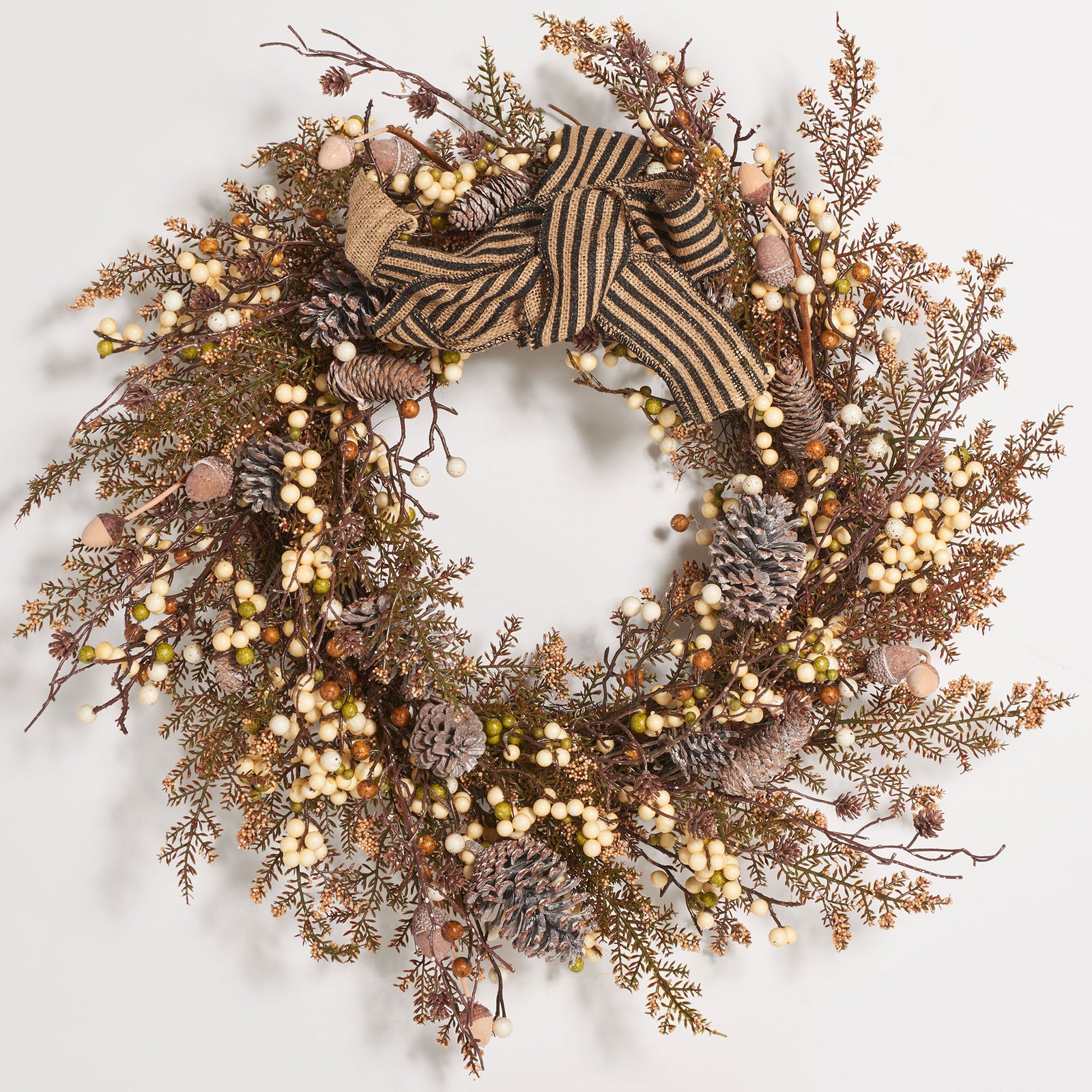 A striped bow crowns an earthy wreath of cream berries and pine cones. || FXP1055A || front_studio