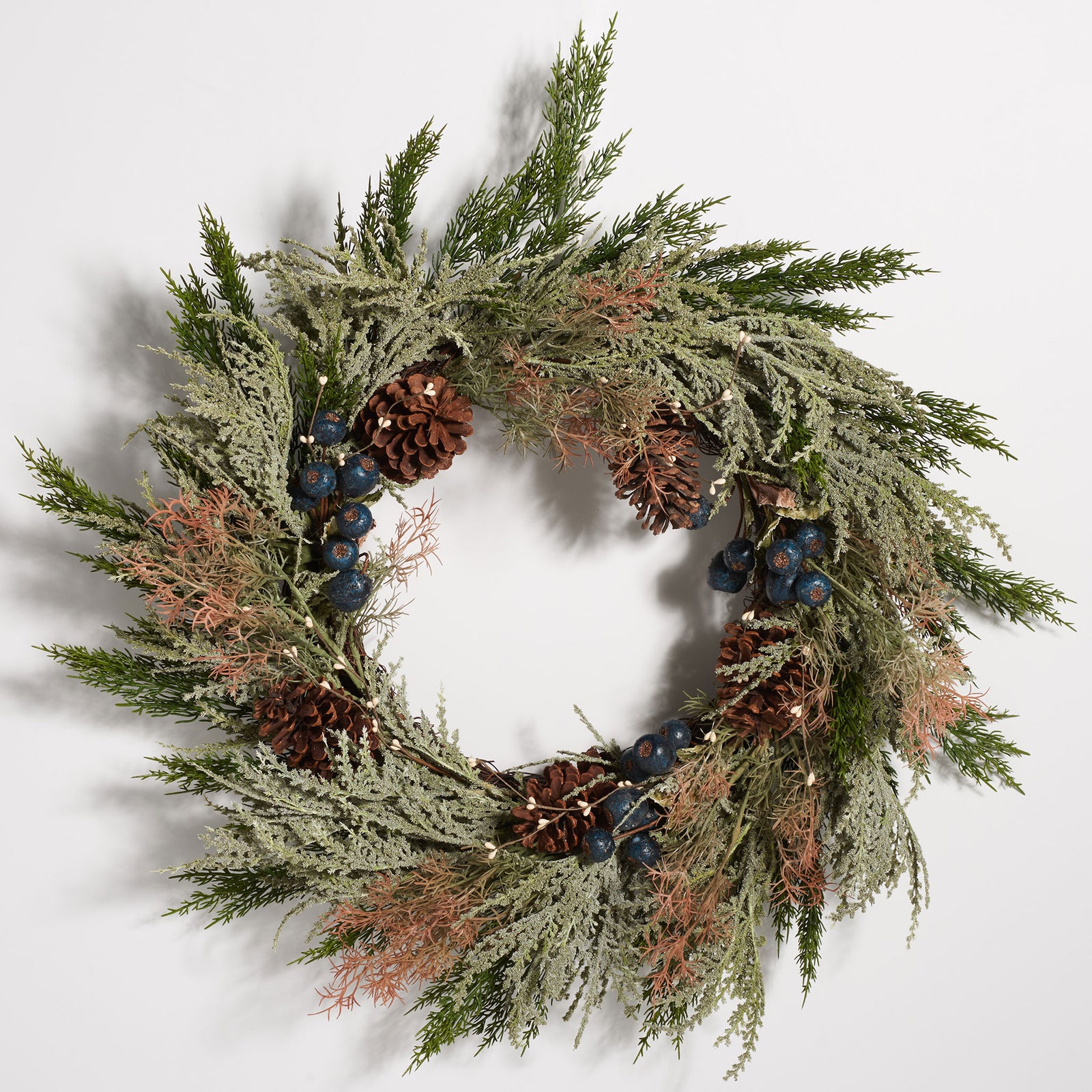 Airy green boughs surround blue berries and natural-looking pine cones. || FXP1094A || front_studio