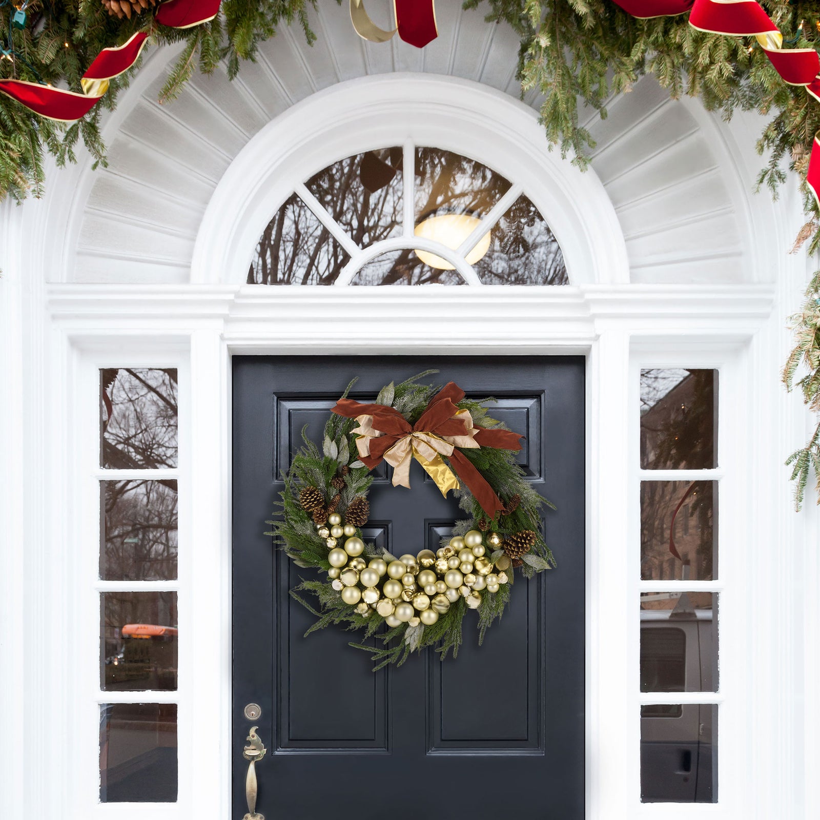 A lush holiday wreath welcomes visitors with shiny ornaments, pine cones, and a festive bow. || FXP1099A || front_room
