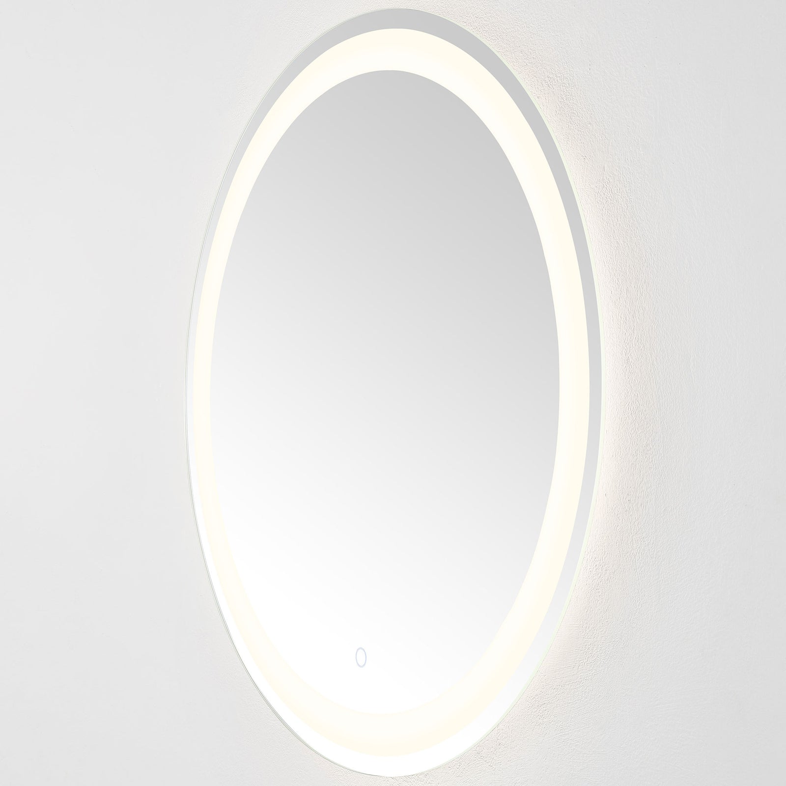 The slim, wall-mounted mirror casts a soft white glow from its circular LED band || LMR1001A || side_on_studio