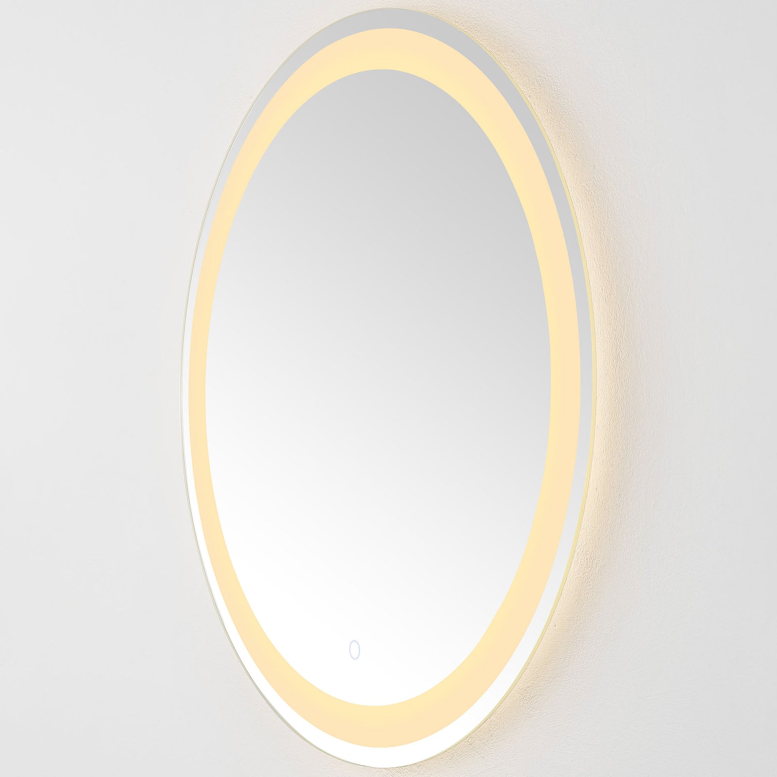 Warm LED light radiates from the round mirror's perimeter beside its slim silver edge || LMR1001A || side_on_studio