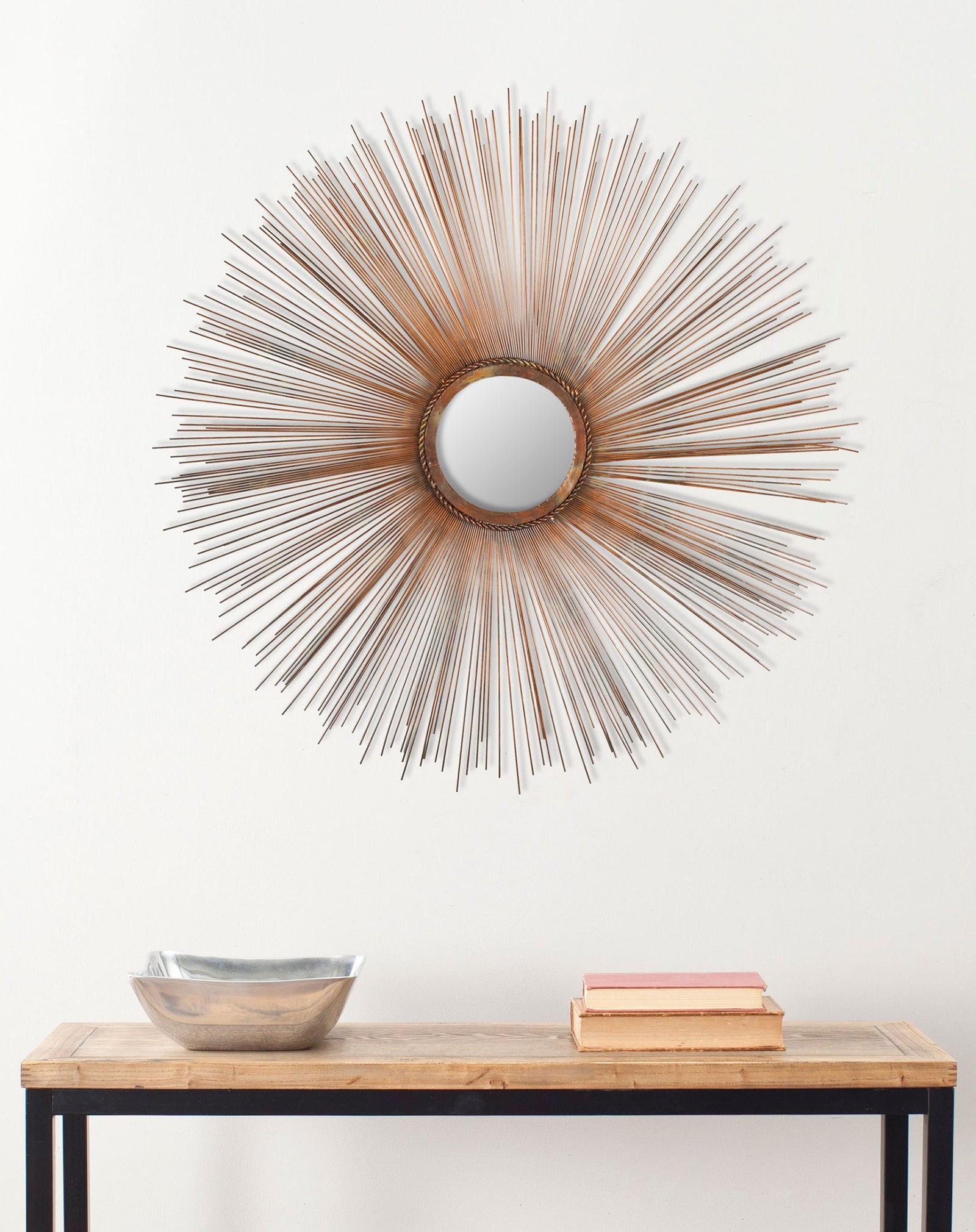 Slender copper spokes surround a round mirror above a wood console || MIR3002A || front_room