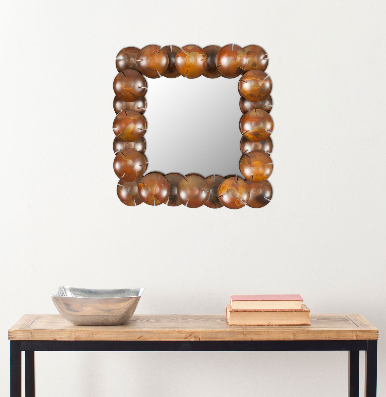 A square wall mirror framed by copper-toned discs adds sculptural warmth above a slim console. || MIR3005A || front_room