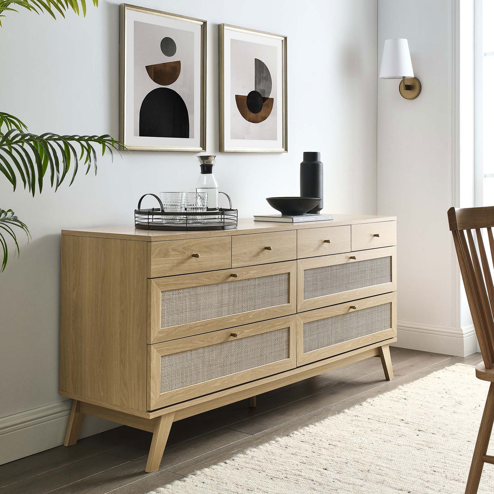 Oak 8-drawer dresser with rattan fronts styled in a bright modern room with wall art and greenery || MOD-7054-OAK || front_angle_room