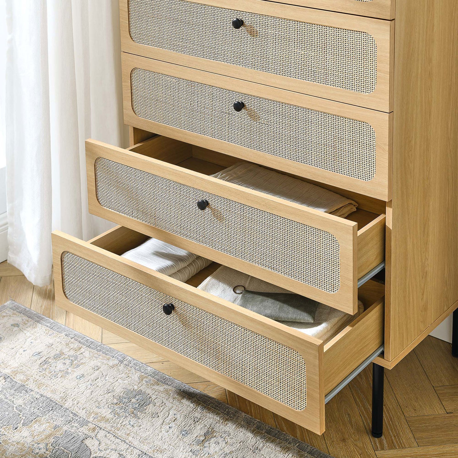 Oak rattan-front chest in a bright bedroom with lower drawers open and neatly organized linens || MOD-7065-OAK || front_angle_open_room