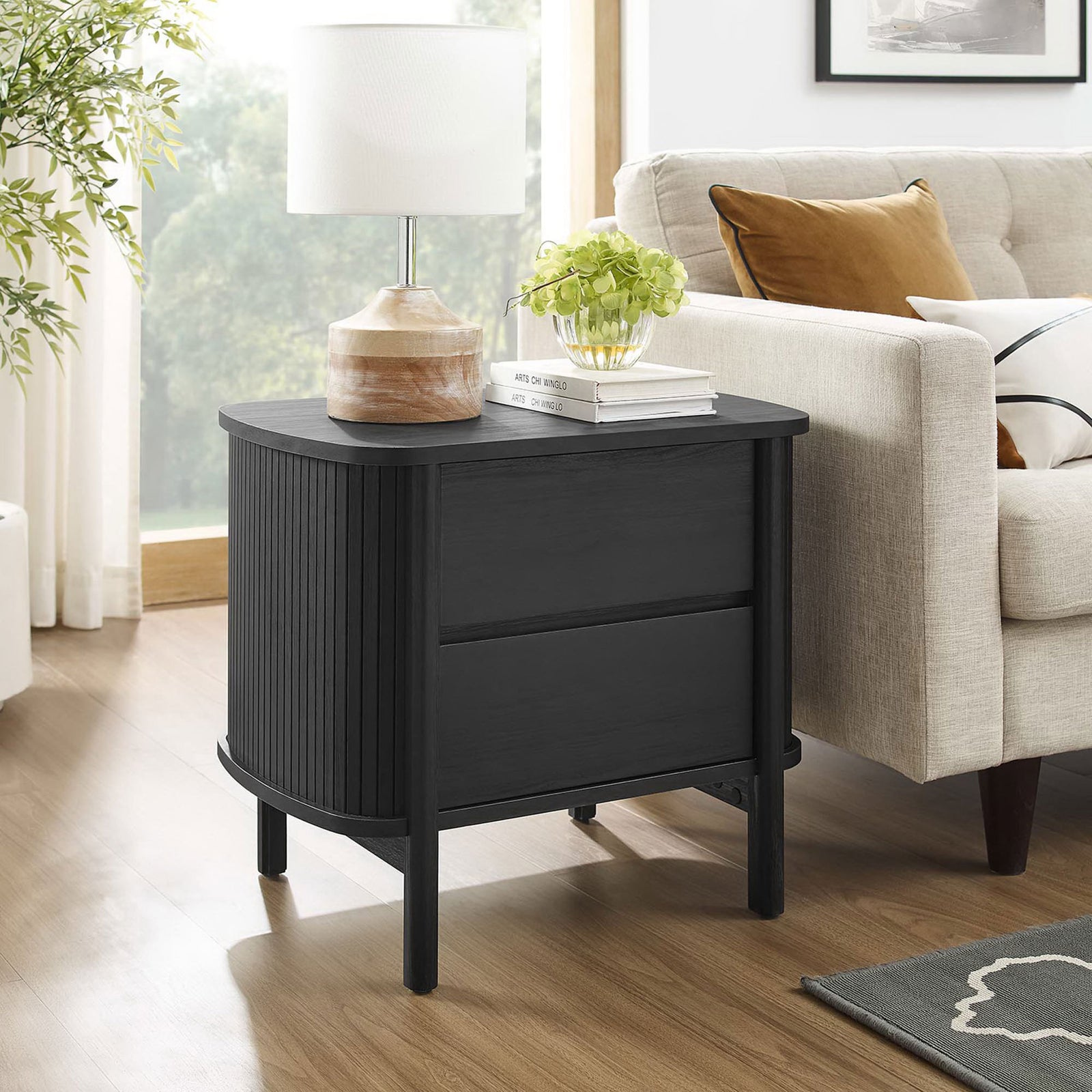Black Cadence nightstand used as a living room side table beside a sofa with decor and table lamp || MOD-7158-BLK || front_angle_room