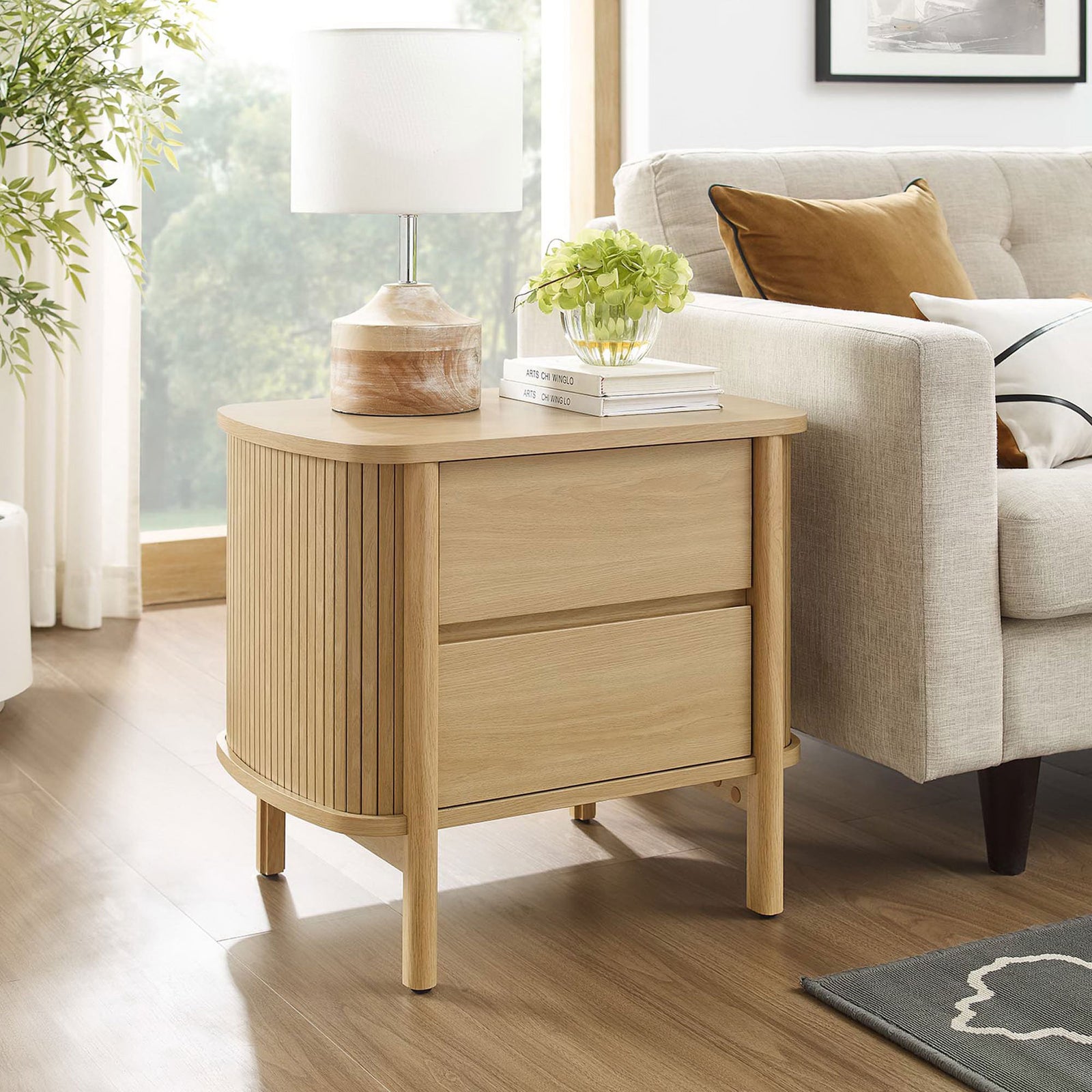 Cadence oak nightstand used as an end table next to a sofa, adding warm texture to the living room. || MOD-7158-OAK || front_angle_room