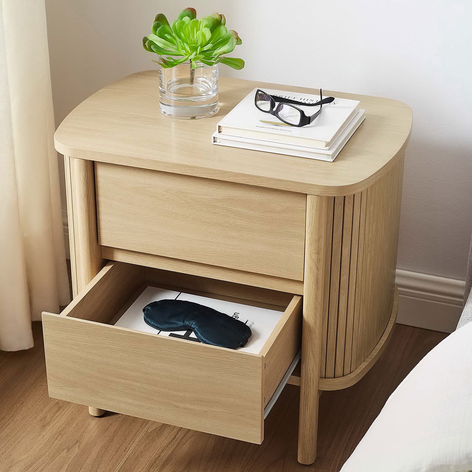 Cadence oak nightstand styled beside a bed with an open drawer for keeping nighttime essentials handy. || MOD-7158-OAK || front_angle_open_room