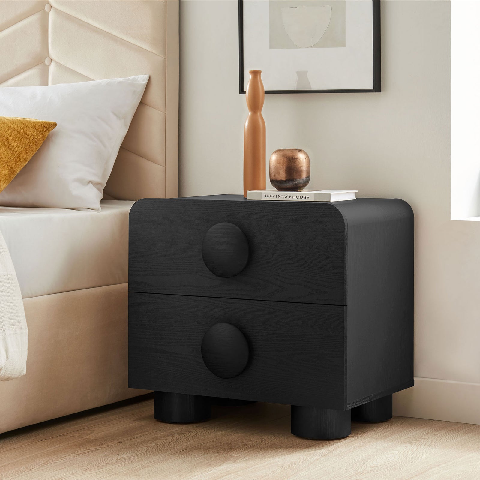 Black two-drawer nightstand beside a modern upholstered bed, topped with decor for a cozy bedroom look || MOD-7181-BLK || front_angle_room