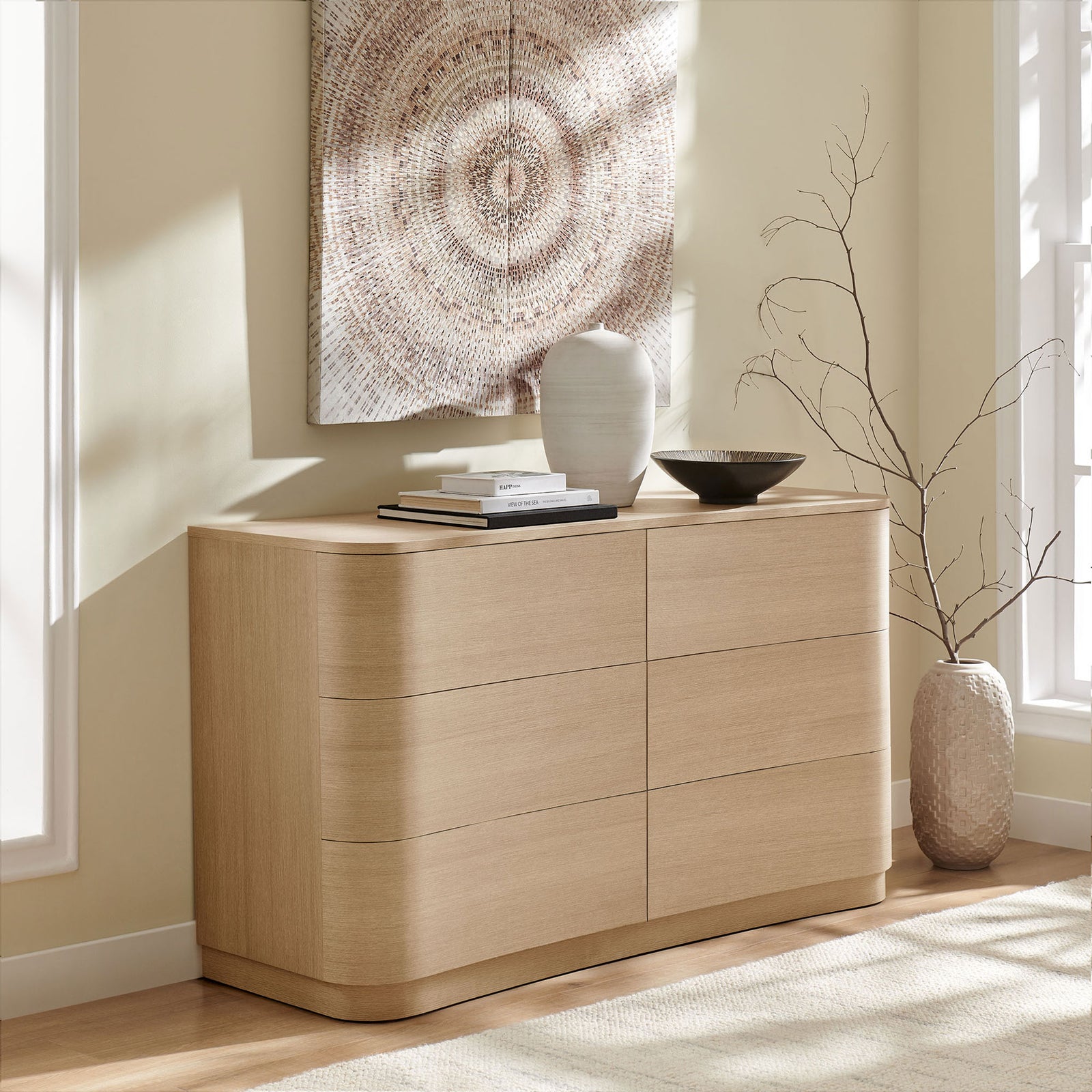 Curved light oak dresser styled in a sunlit room with neutral art and ceramic decor accents || MOD-7229-BOA || front_angle_room