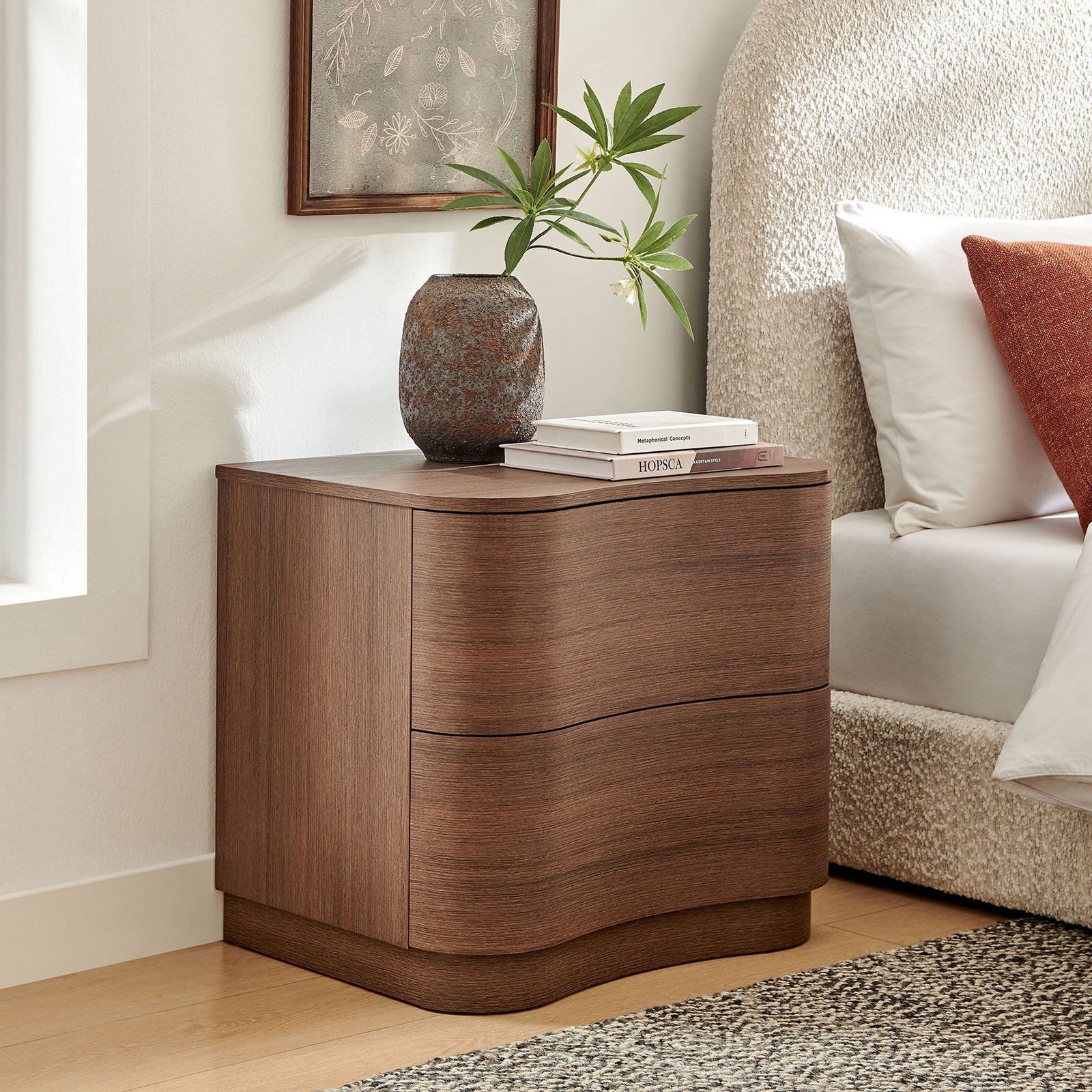 Mirae nightstand styled by the bedside adds sculptural warmth with its curved front design and rich brown finish || MOD-7232-BBO || front_angle_room