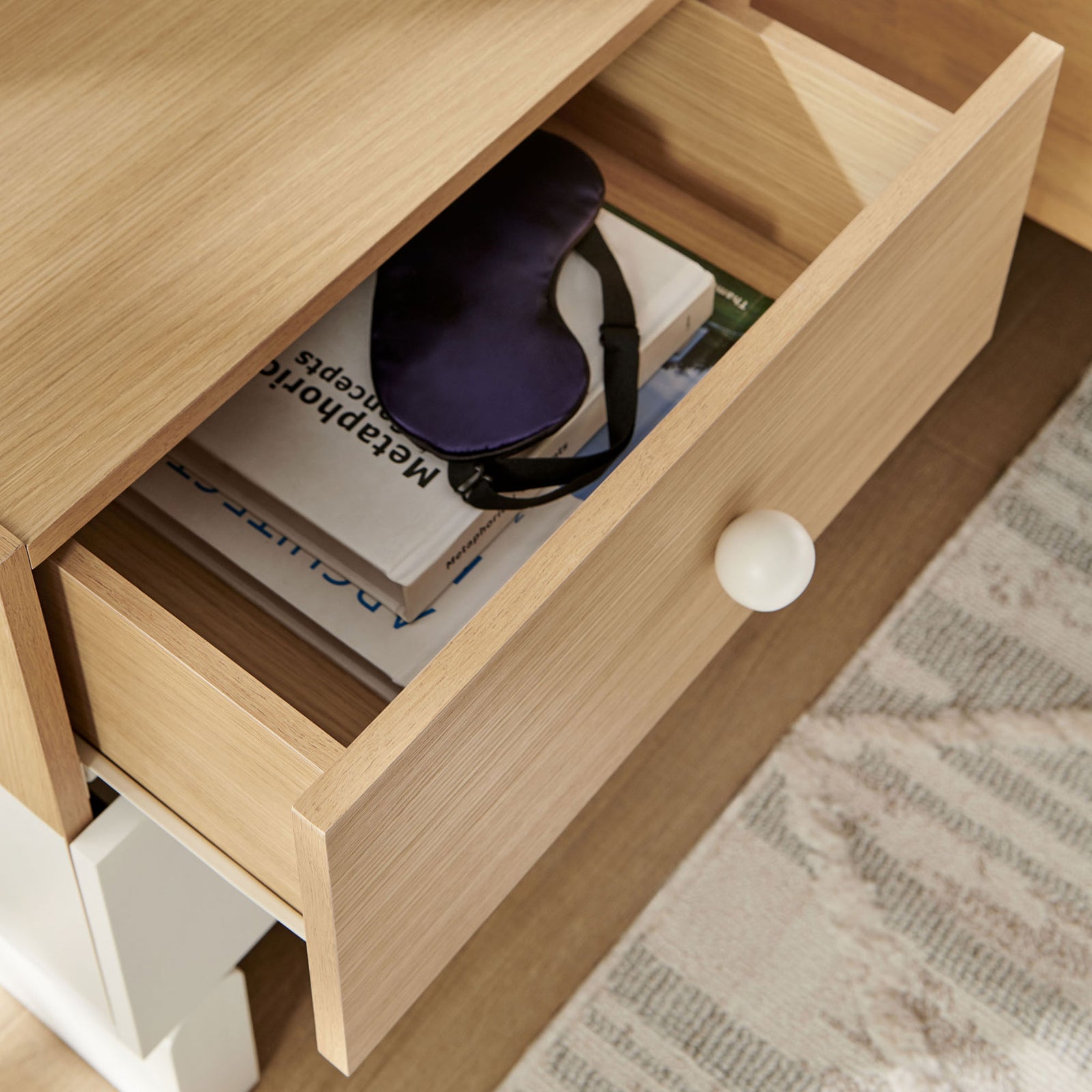 Open top drawer neatly storing books and essentials in the oak and white Nolia nightstand || MOD-7238-OAK-WHI || storage_open_room