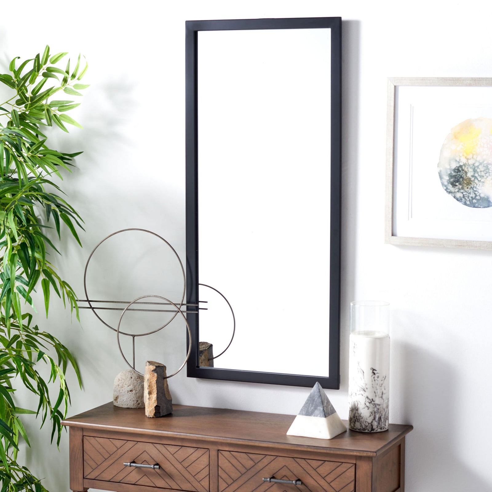 A tall black-framed mirror brings clean lines to the wall above a wood console. || MRR2005C || front_angle_room