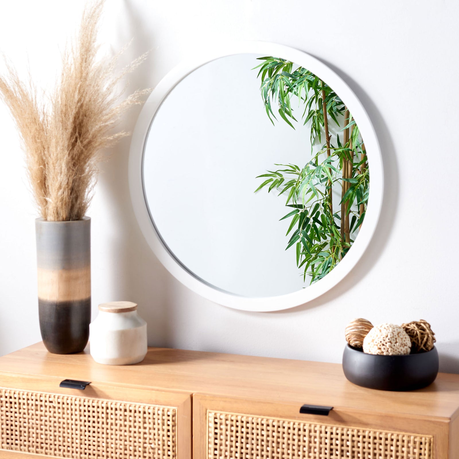 A round white-framed mirror adds a fresh, airy accent above a warm wood cabinet || MRR2006A || front_angle_room