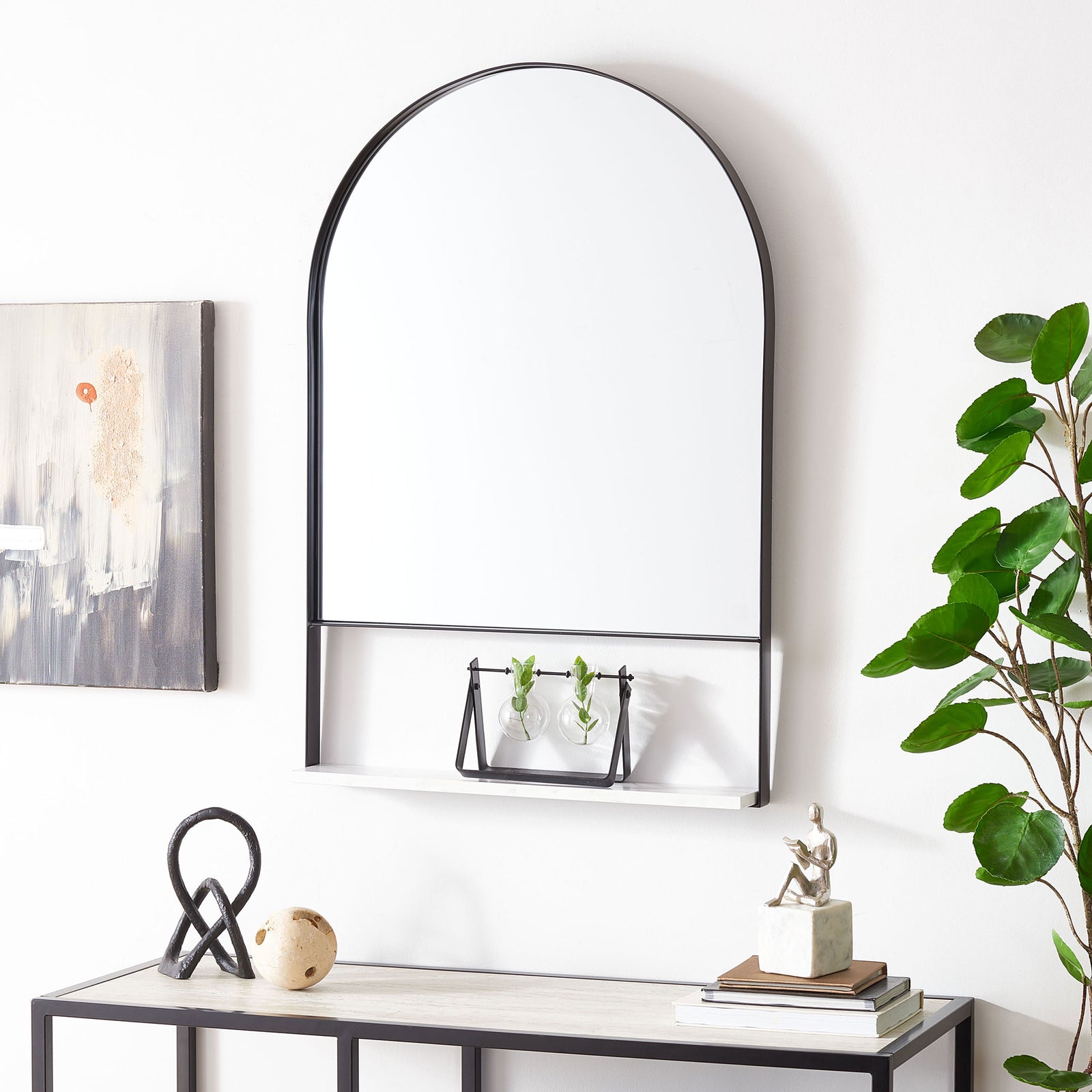 A black-framed arched mirror and white shelf add space for accents above a console. || MRR2009C || front_room