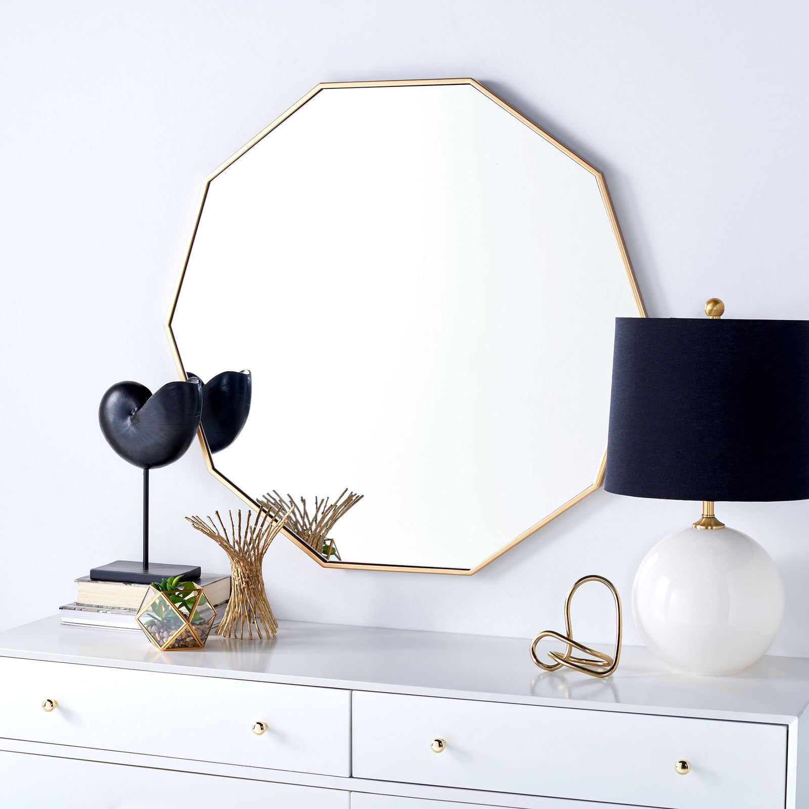 Brass-finished geometric mirror adds a warm accent above a white dresser || MRR2010A || front_room