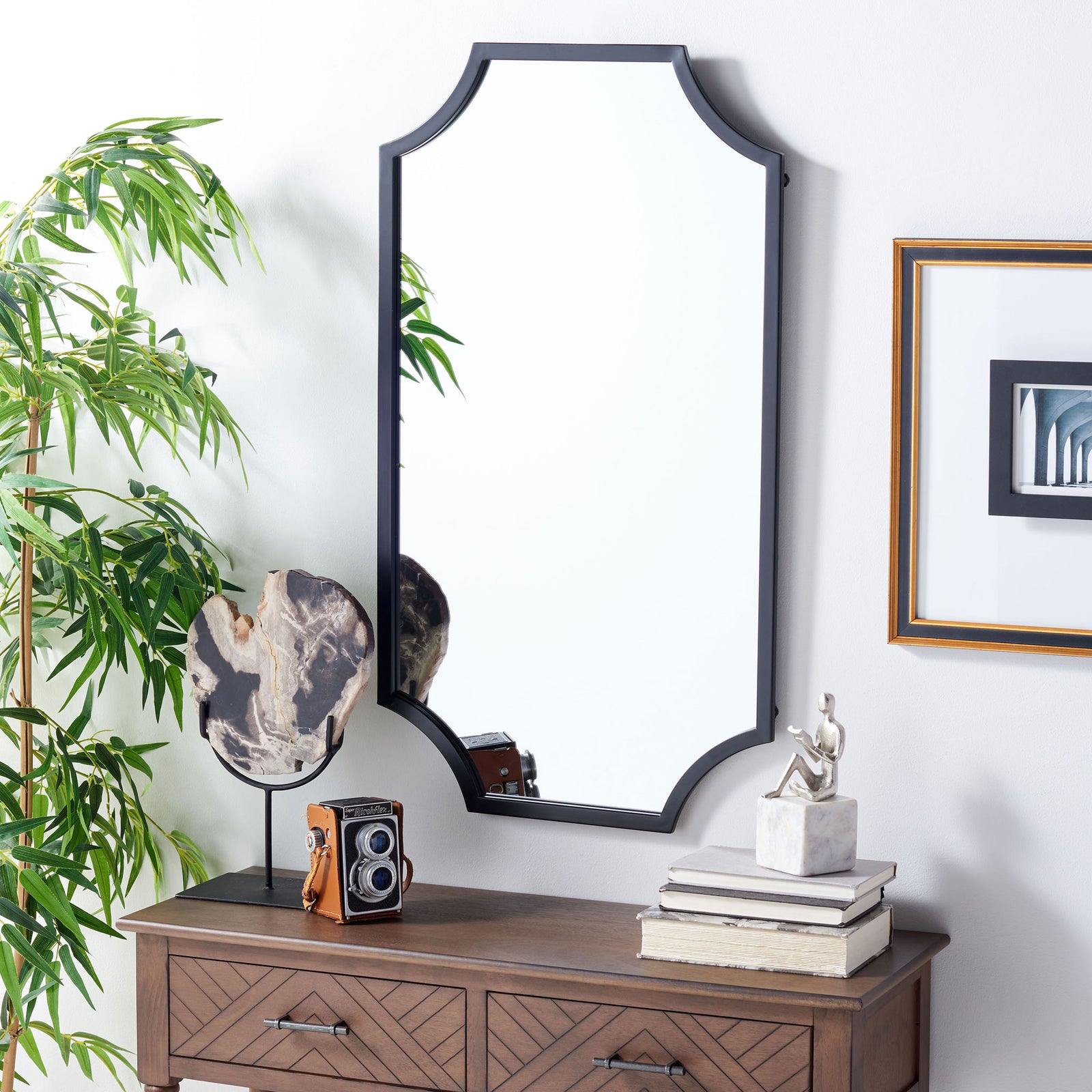 The black-framed mirror adds crisp contrast above a wooden dresser. || MRR2012B || front_room