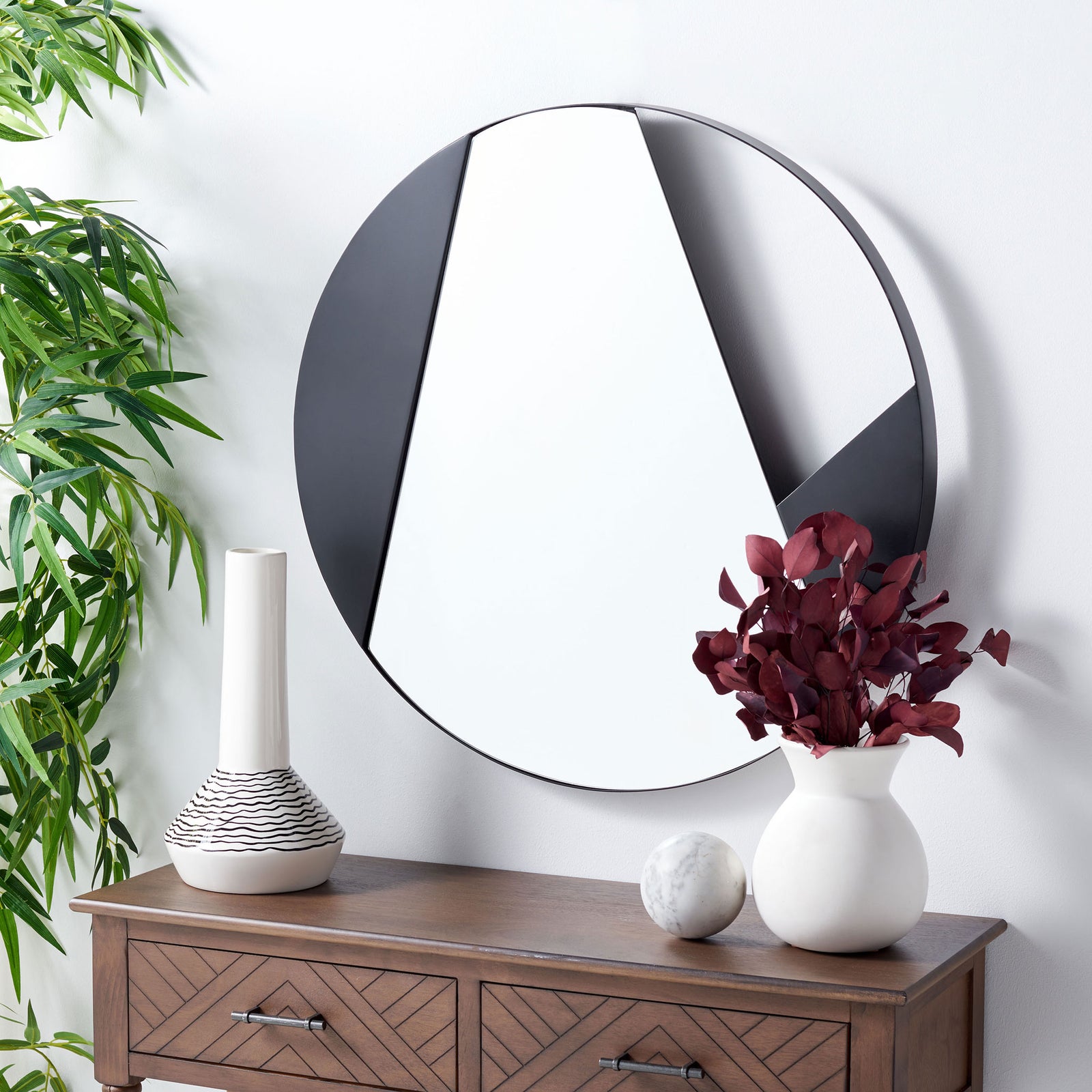 Sweeping black shapes give this round wall mirror sculptural presence above a console. || MRR3039A || front_room