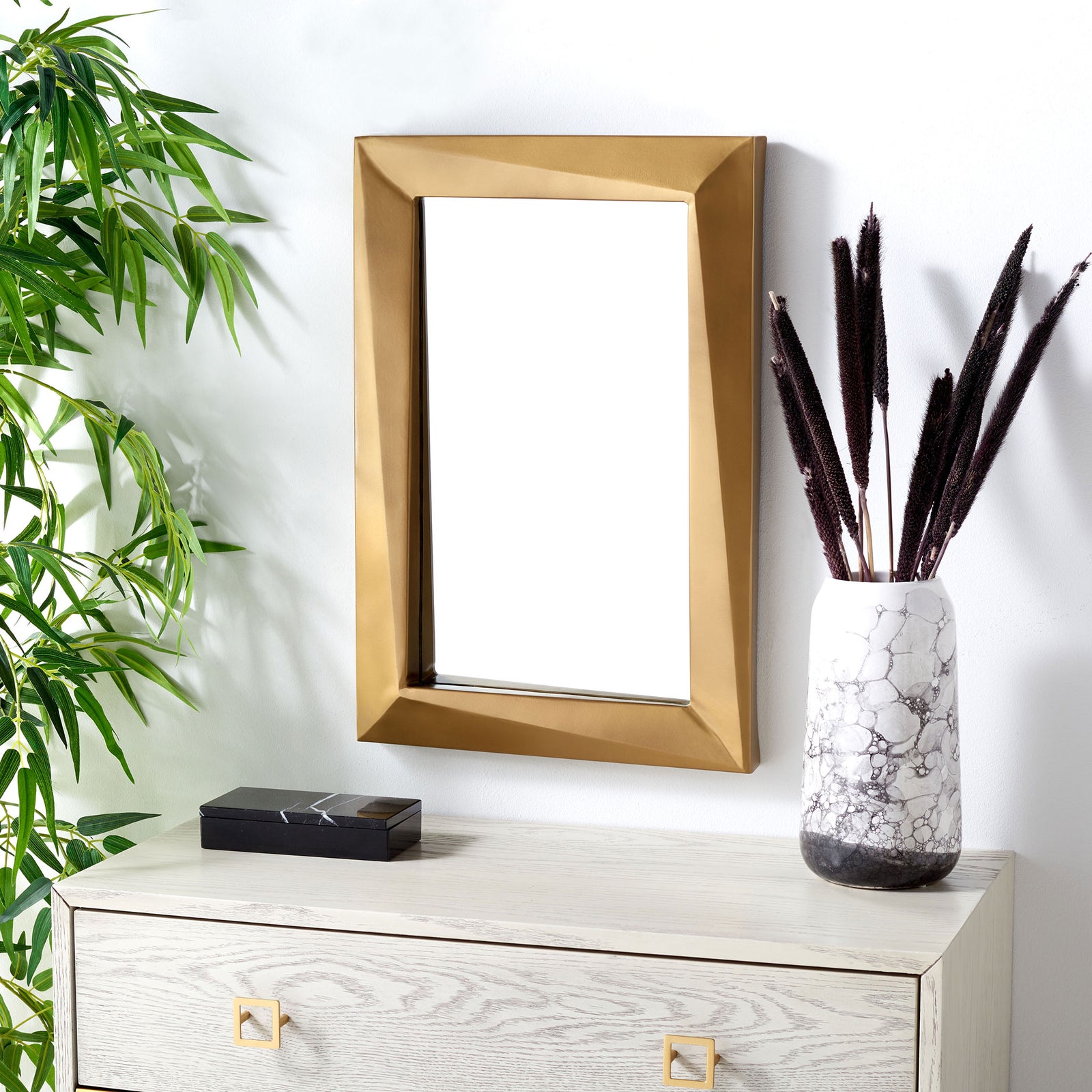 Sculptural brass framing brings warmth to the wall above a light wood dresser. || MRR3041A || front_room