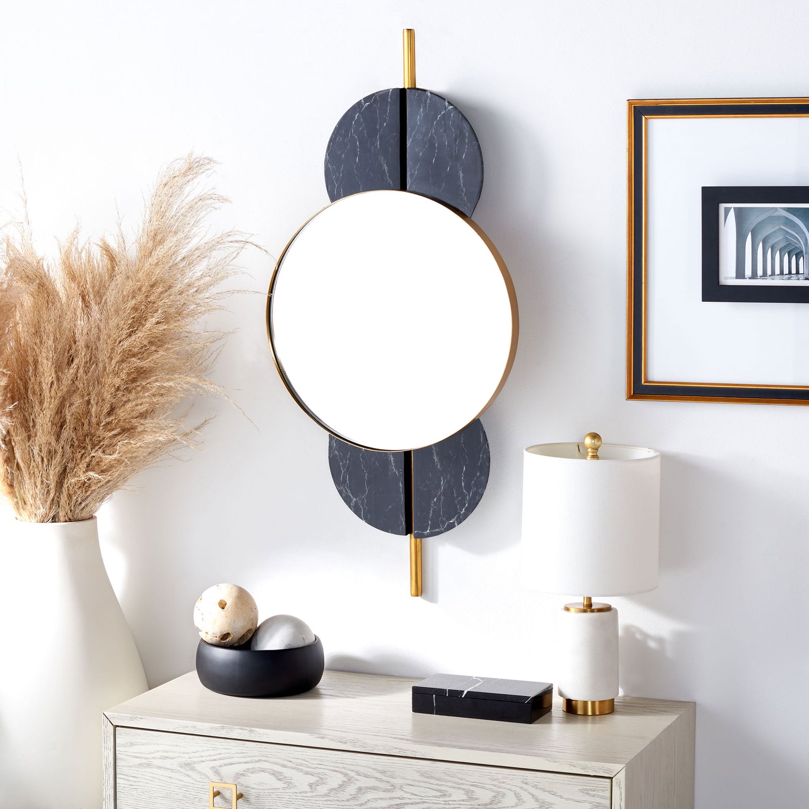 A gold-trimmed round mirror and black marble-look accents bring contrast above a light-toned dresser || MRR3048B || front_angle_room