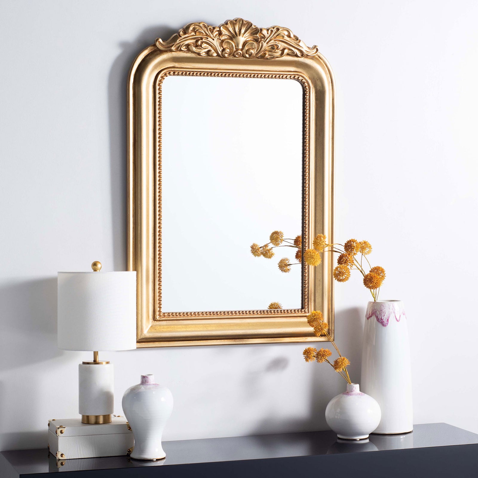 Antique gold mirror adds ornate scrollwork above a display of decorative vases || MRR5000A || front_room