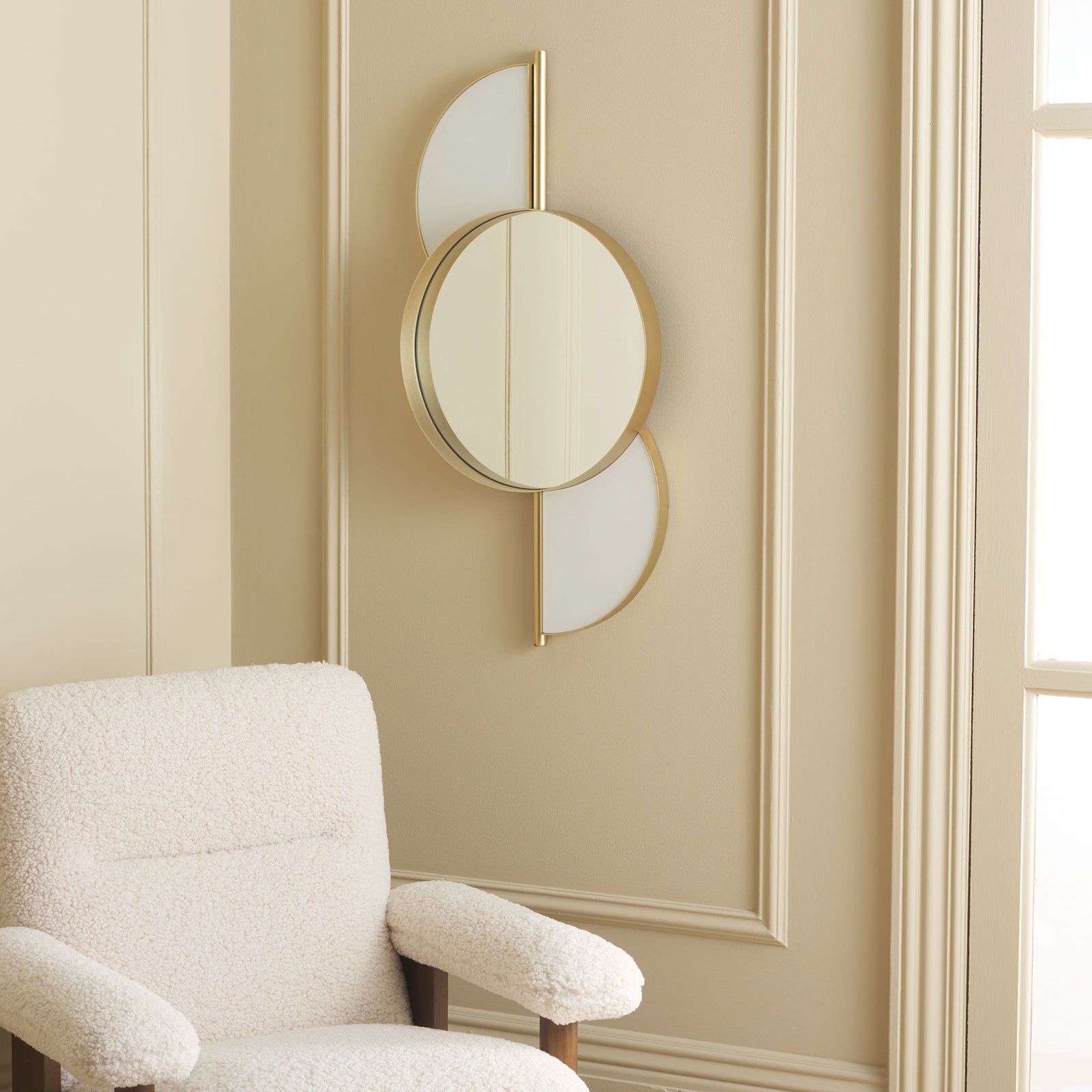 A gold-framed circular mirror and white curved accents brighten a paneled wall || MRR8004B || front_angle_room