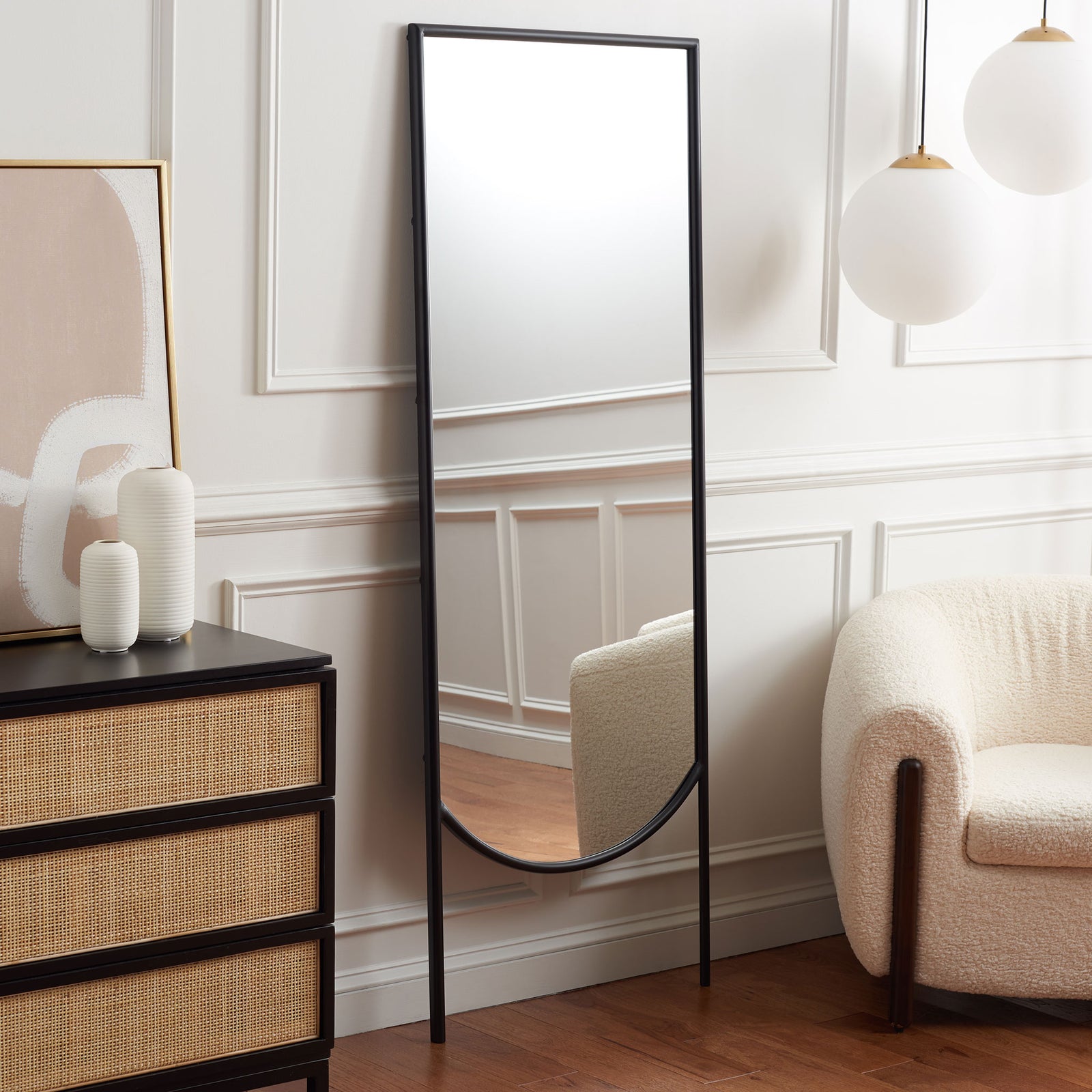 A tall black iron mirror adds height and a softly curved accent to a living room || MRR8005A || front_angle_room