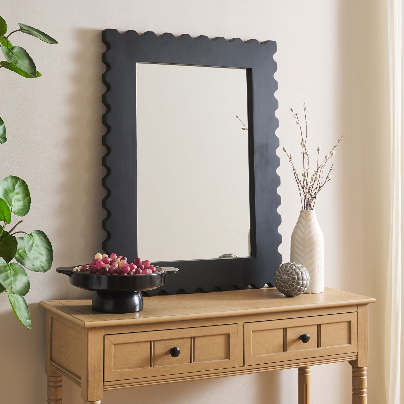 Black scalloped mirror brings sculptural contrast above a light wood console || MRR9005A || front_room