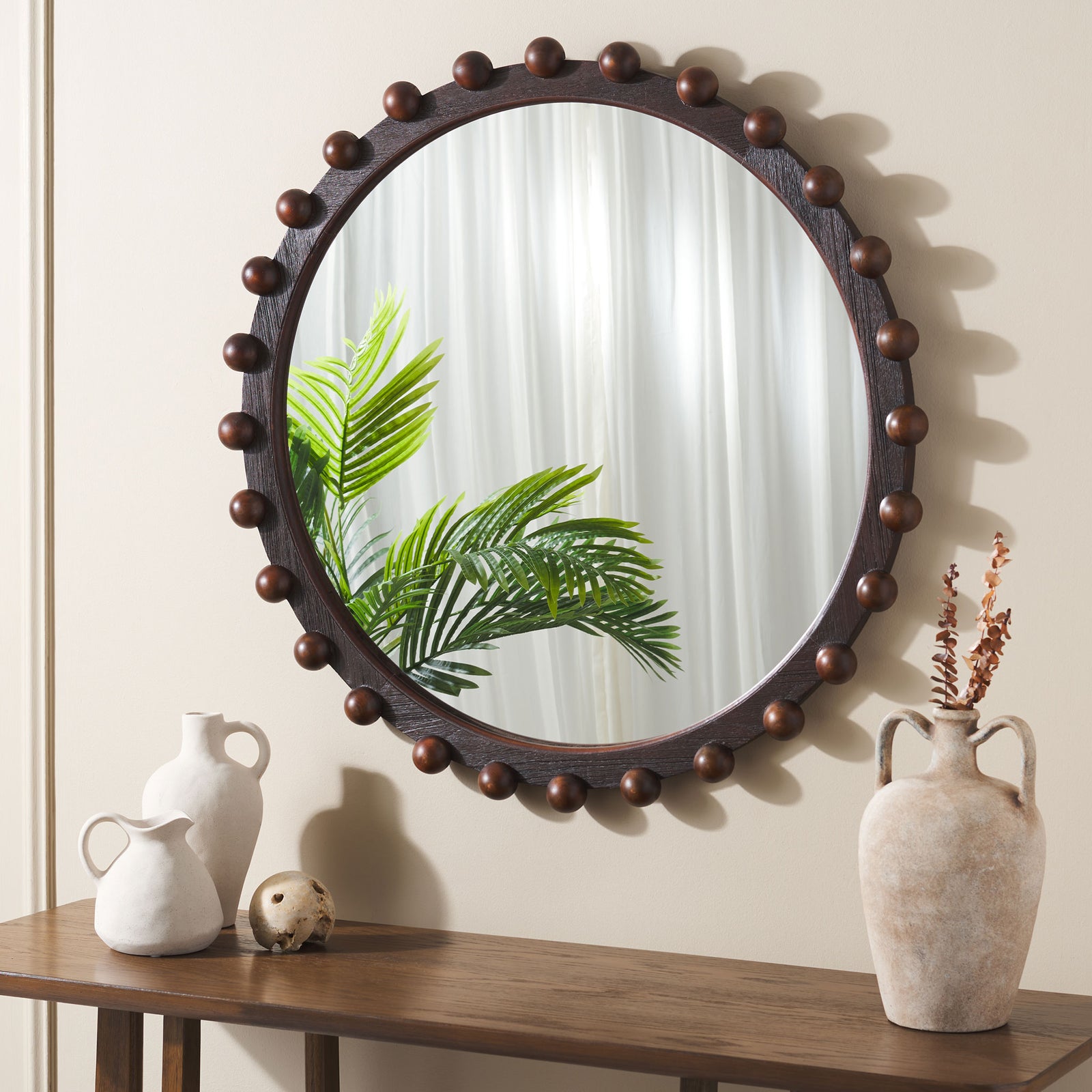 Walnut-finished round mirror with wood bead accents brings warmth to a wall above a console || MRR9026A || front_room