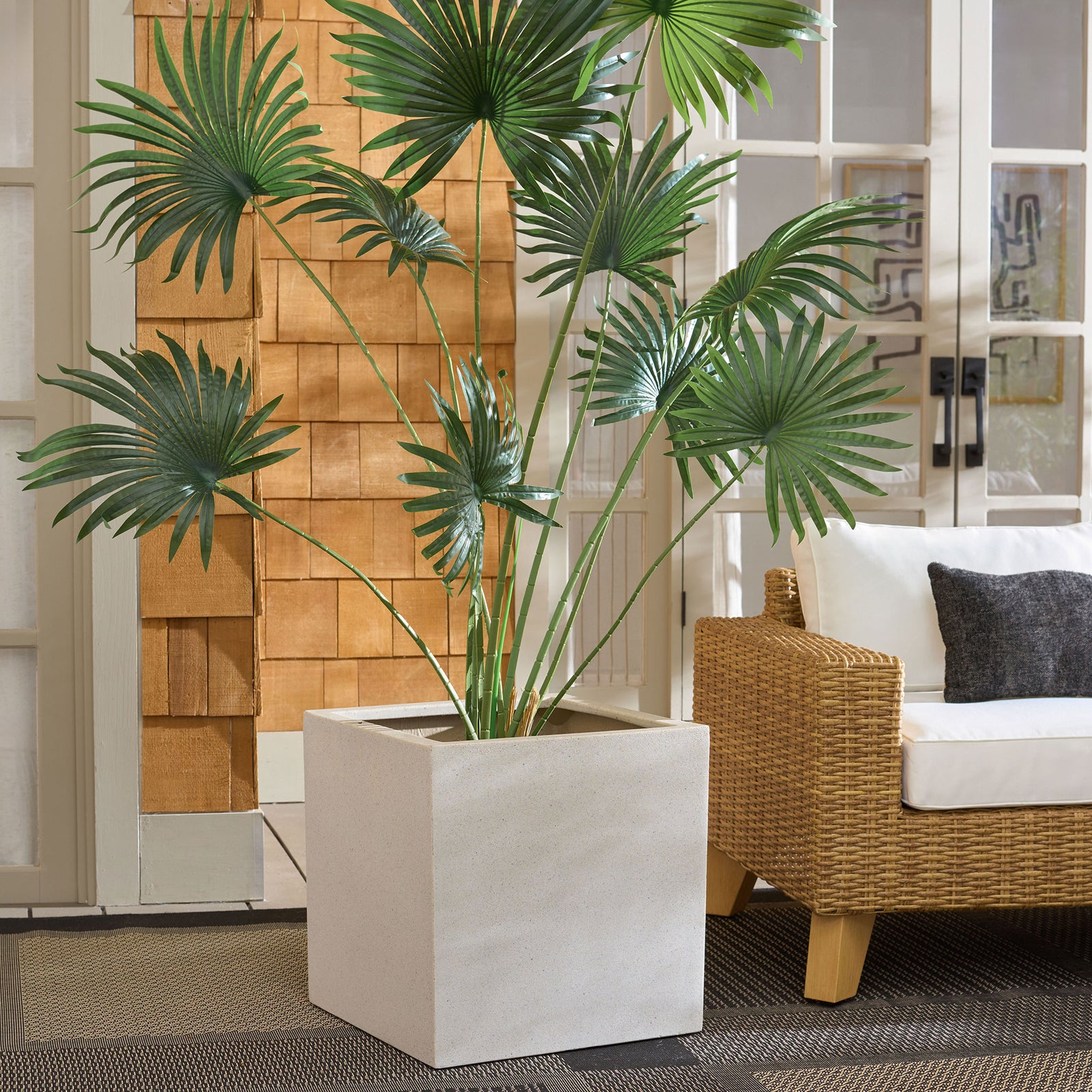 Wide beige square planter anchors leafy greenery beside woven patio seating || PAT1403B || front_angle_room