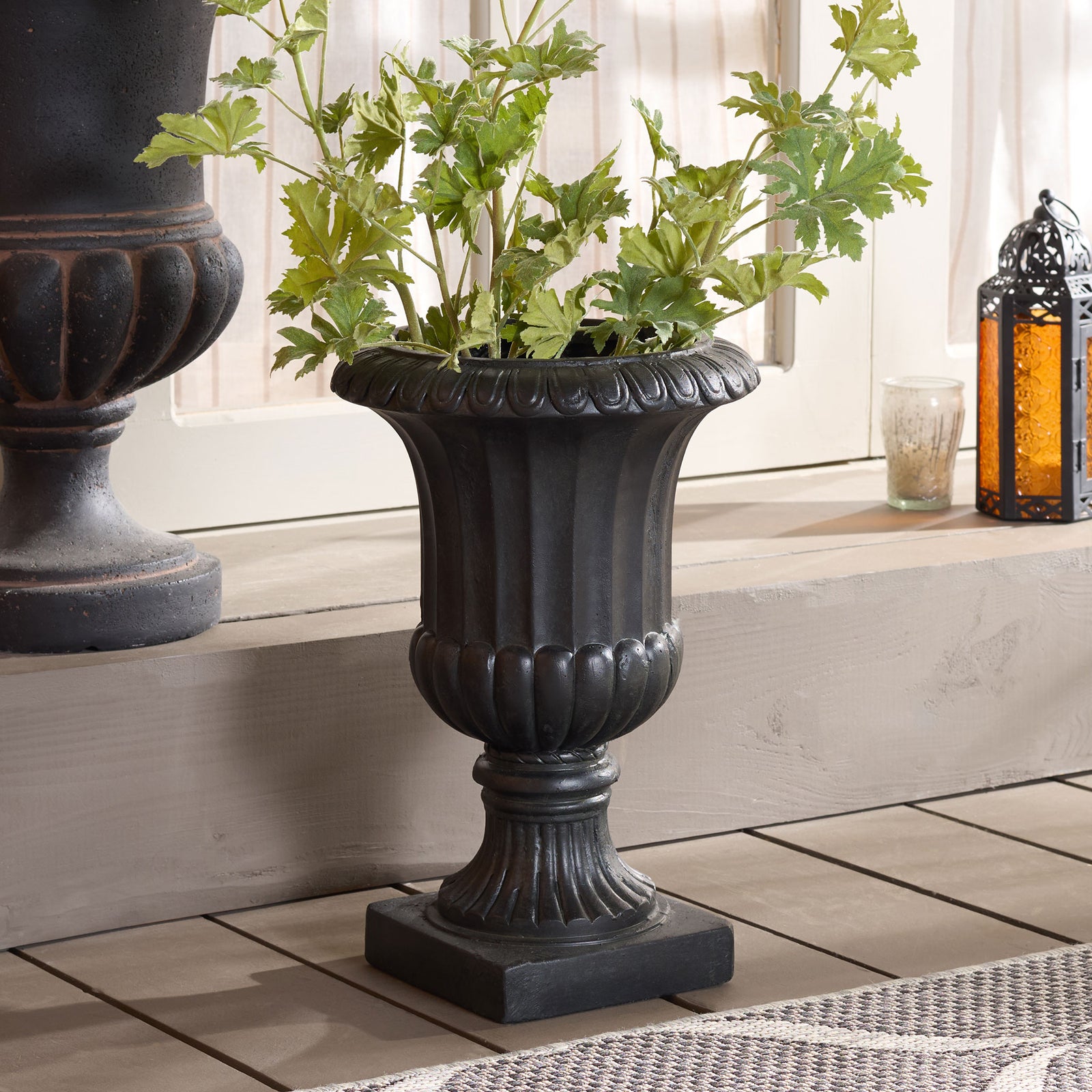 Leafy greenery fills the black pedestal planter, bringing sculptural urn detailing to a tiled space. || PAT5045E || front_angle_room