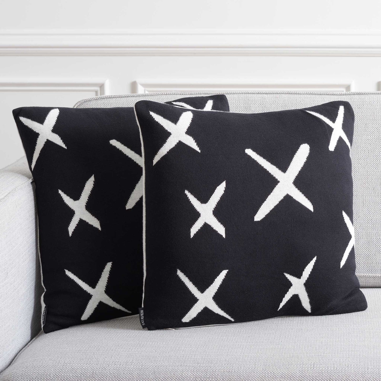 Pair of black X-pattern pillows adding graphic contrast on a light sofa. || PLS404A-1818-SET2 || front_angle_multi_room