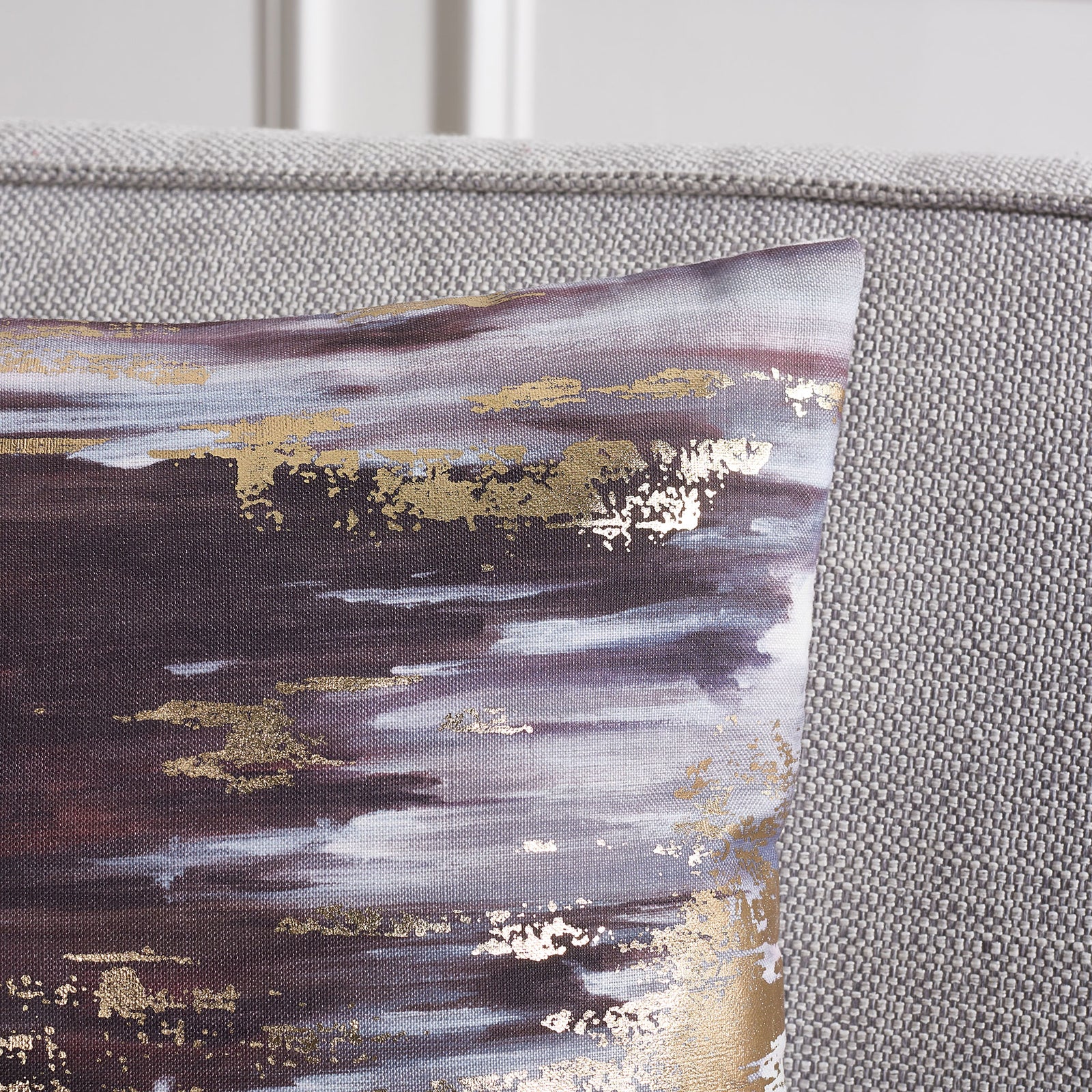 Shimmering gold accents highlight layered navy and gray brushstrokes on the pillow. || PLS7197C-1818 || detail_room