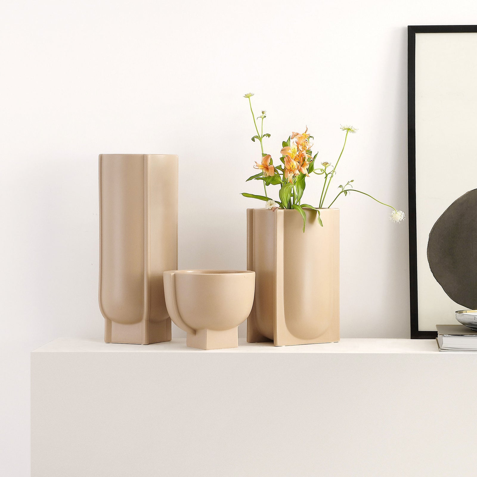 Sculptural taupe vases add varied heights to a shelf, with one holding a loose bouquet of flowers. || RDC4030A-SET3 || front_room