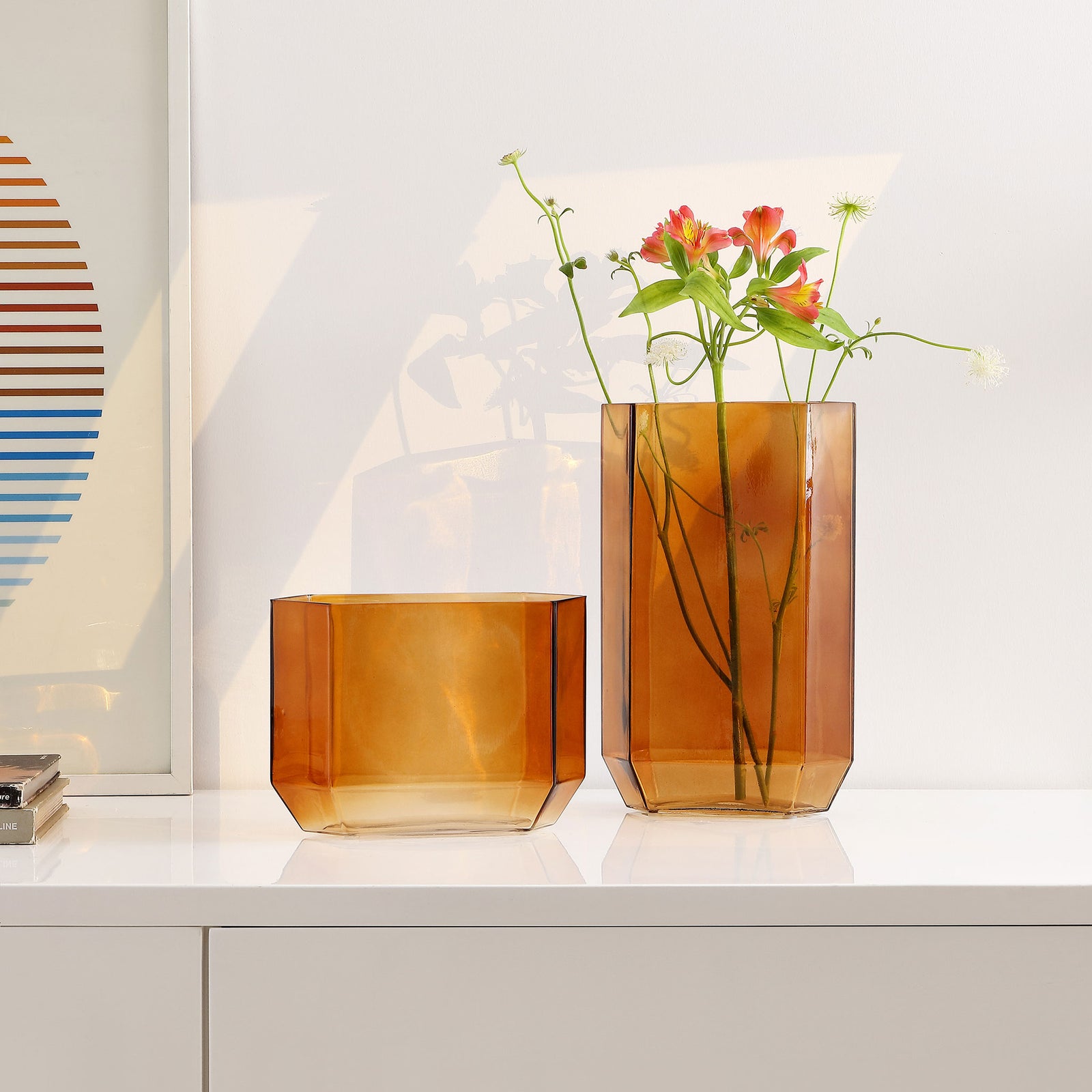Two amber glass vases bring warmth to a white shelf, with colorful flowers displayed in the taller vessel. || RDC4035B-SET2 || front_room