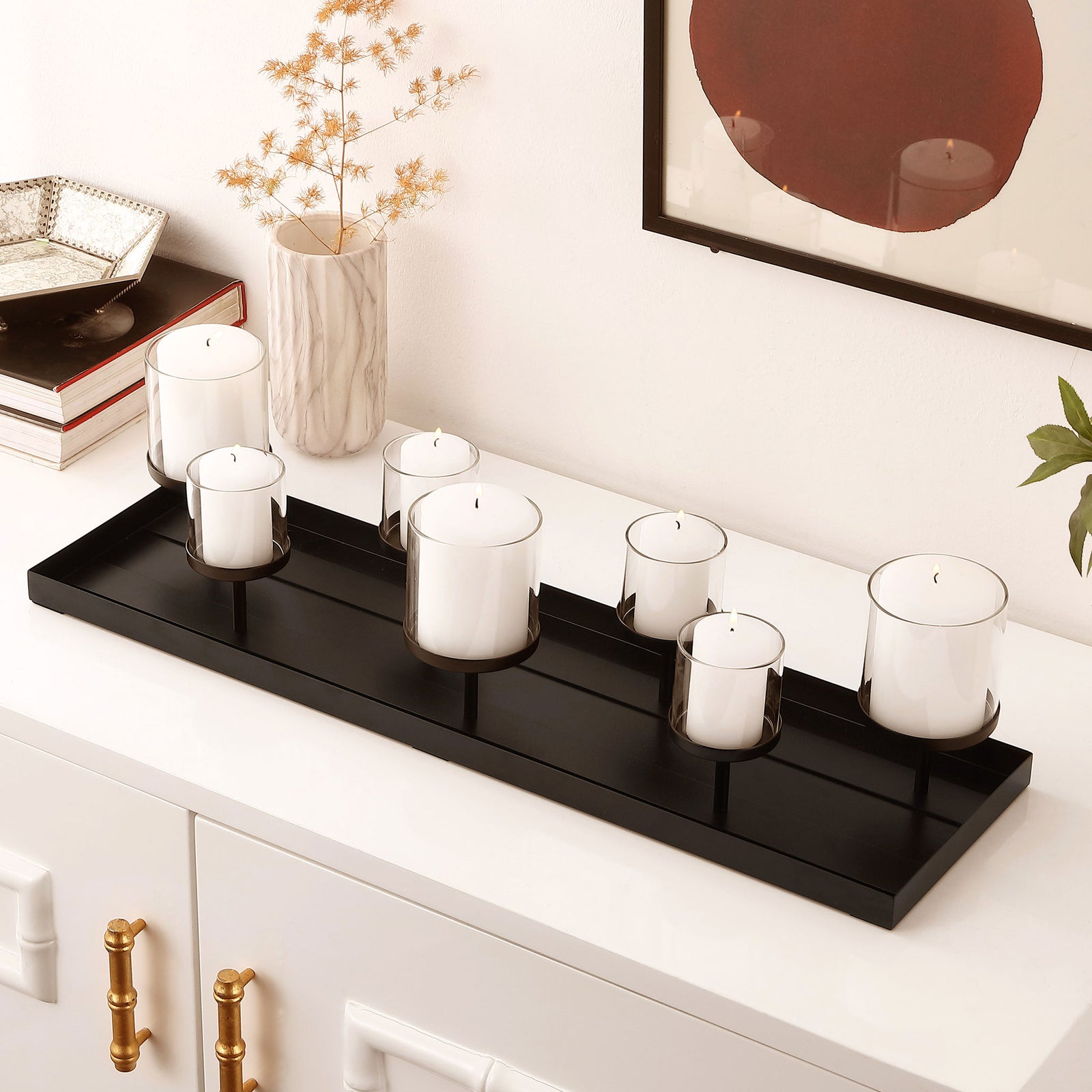 White pillar candles sit in glass cups above a sleek black tray, adding warmth to a modern console. || RDC4040A || front_angle_room