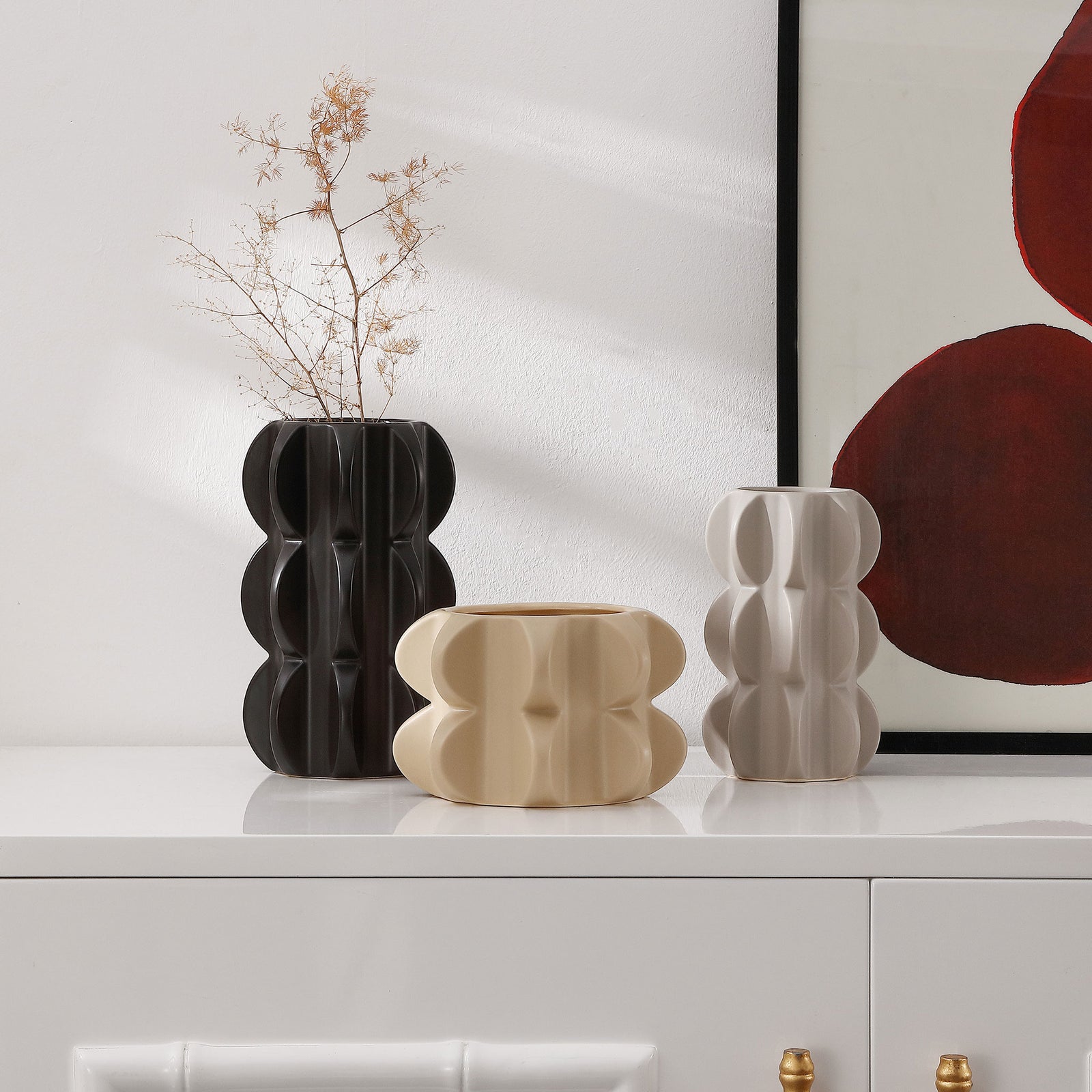Sculptural black, sand, and gray ceramic vases bring organic curves to a console, with branches in the tallest vase. || RDC4048A-SET3 || front_room