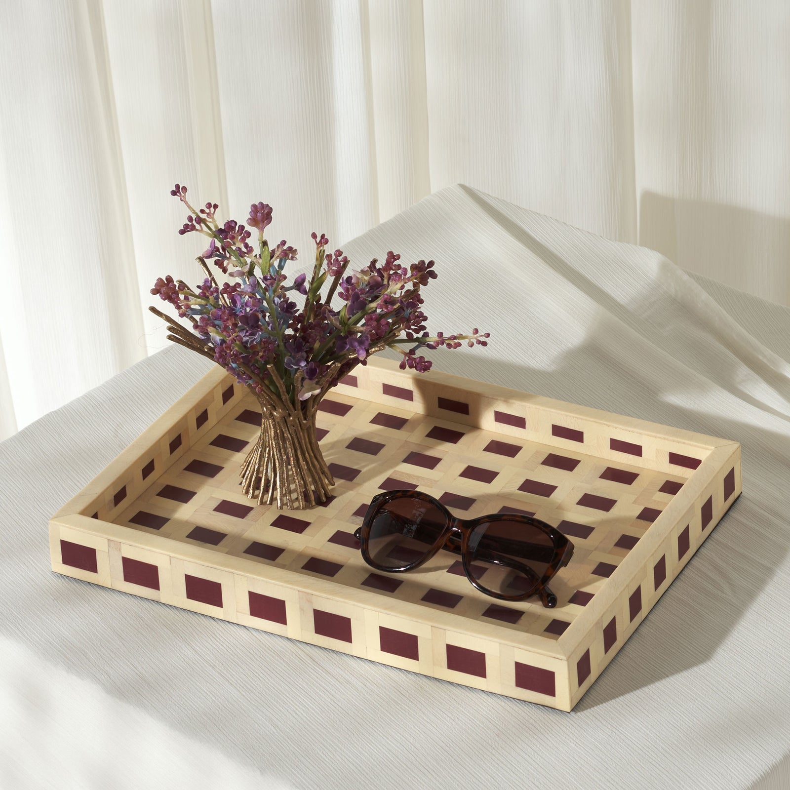 A burgundy-inlaid tray holds flowers and sunglasses on a soft, light-colored seat || RDC5012A || front_angle_room