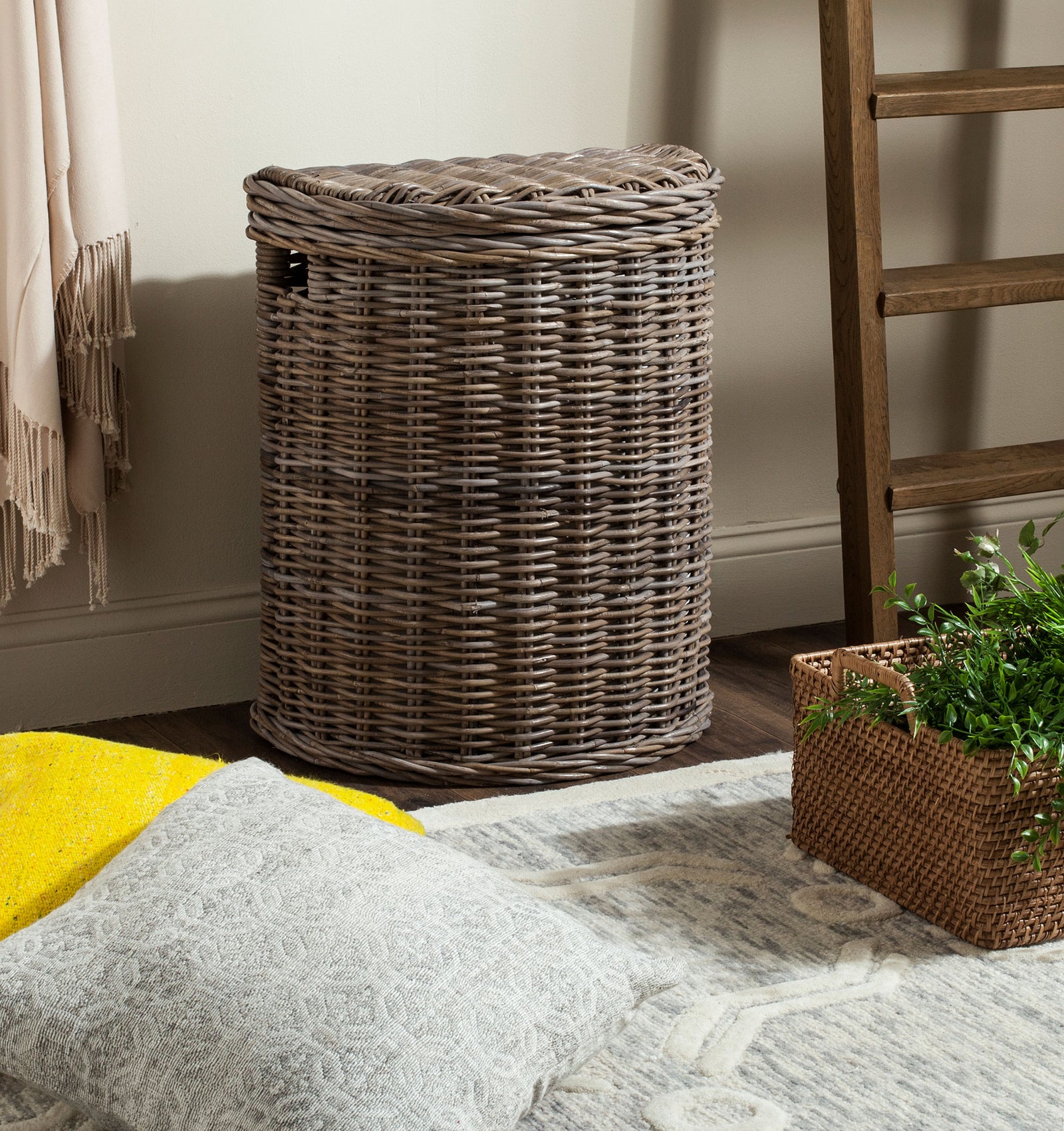 This lidded gray wicker hamper brings practical storage and relaxed texture to a cozy room. || SEA7008A || front_angle_room