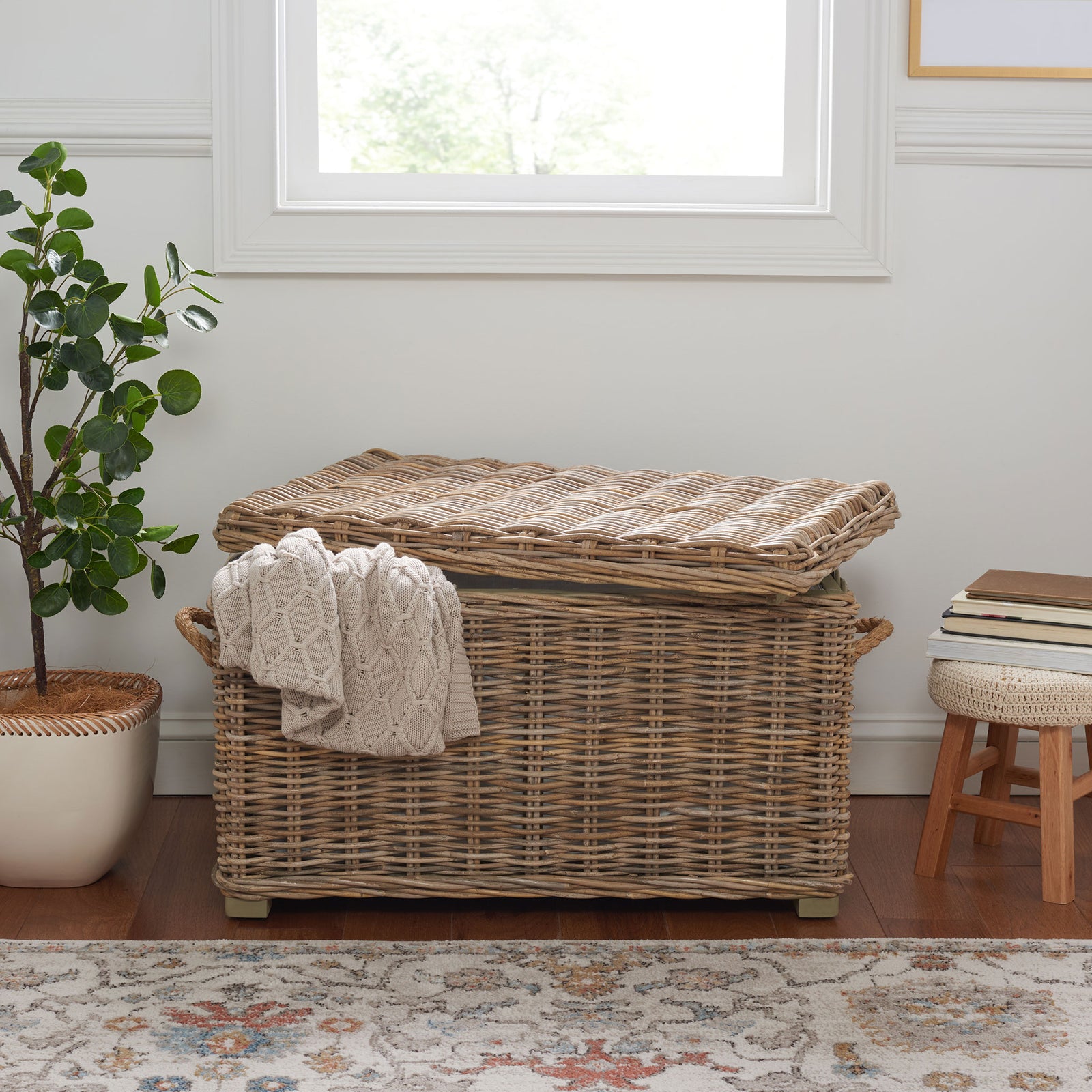A chunky knit throw drapes over the trunk's woven gray sides and sturdy rope handles. || SEA7019A || front_room