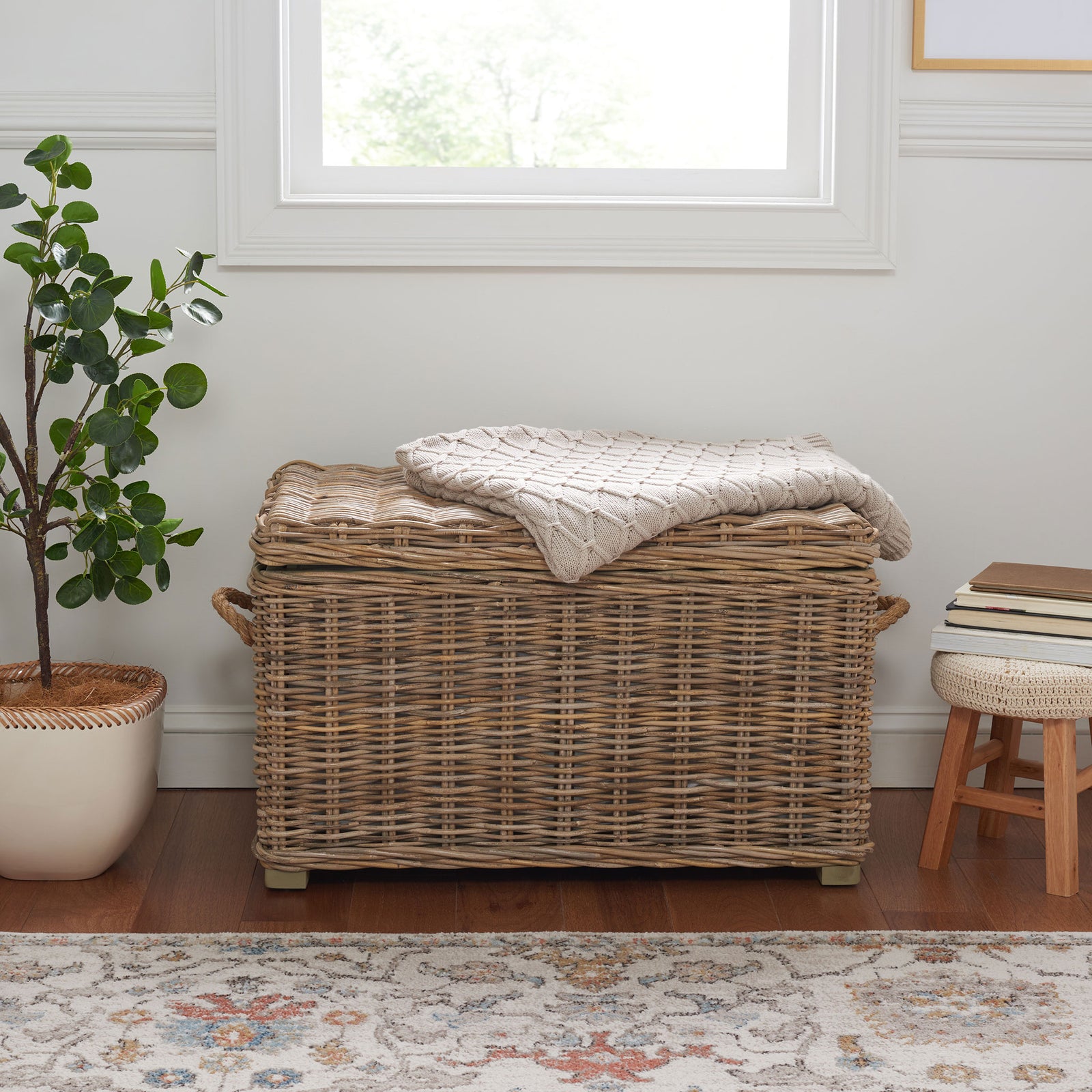 Gray wicker trunk brings natural texture and practical blanket storage to a cozy living space. || SEA7019A || front_room