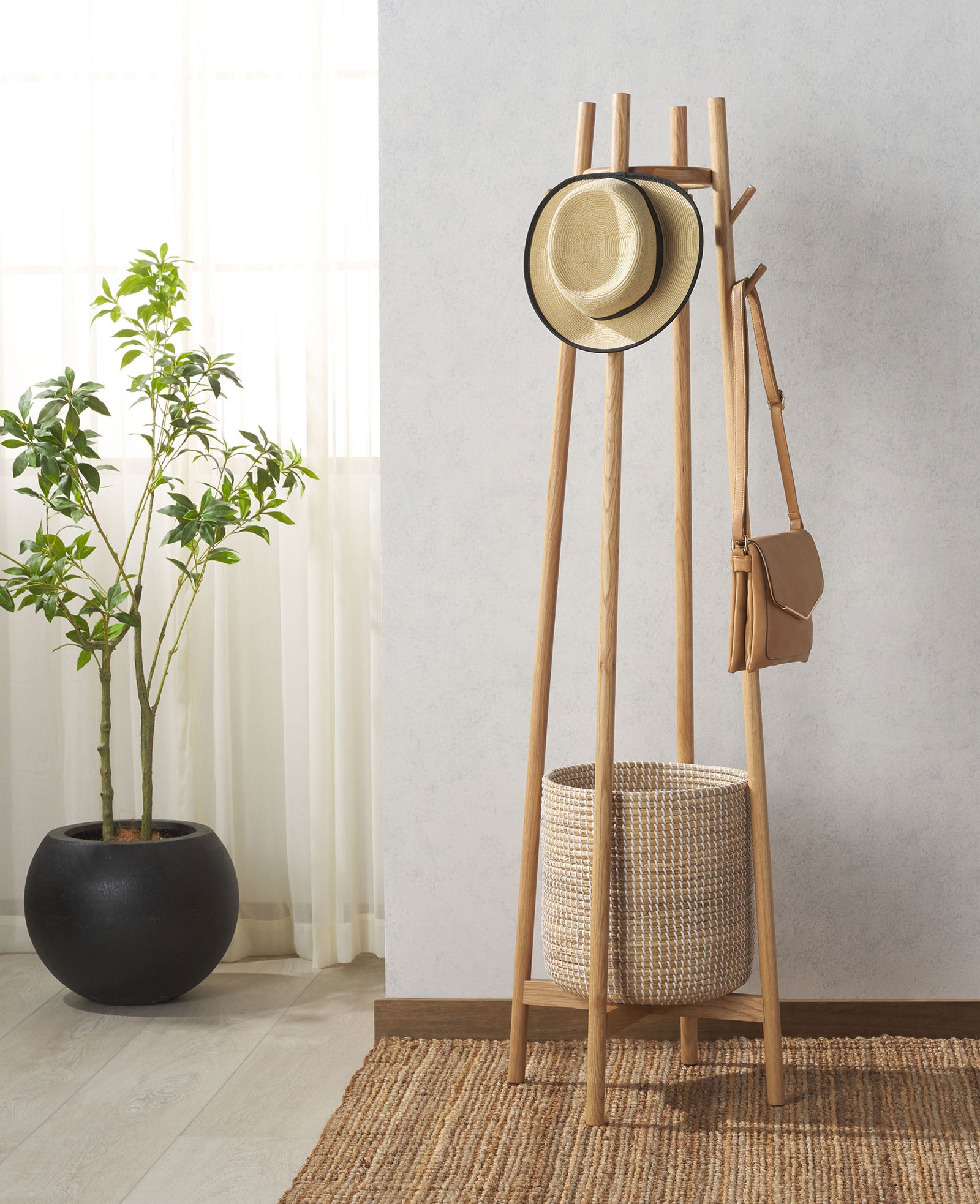 Branching wood hooks hold a straw hat and shoulder bag above a basket for everyday essentials. || SFV4202A || front_angle_room