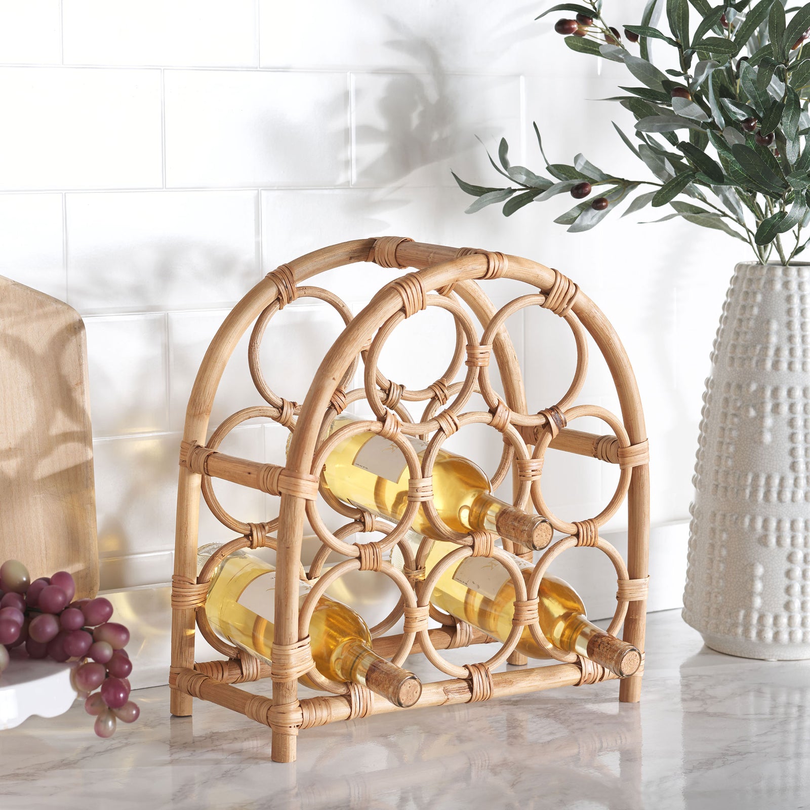 Natural rattan arches hold wine bottles in circular cradles on a kitchen counter || STG1801A || front_angle_room