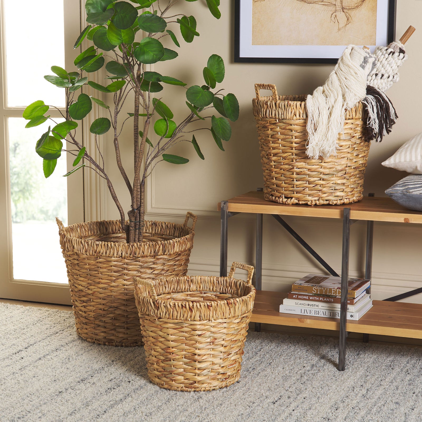 Graduated woven baskets hold a leafy plant and soft throws while warming up a living space. || STG1807A || front_room